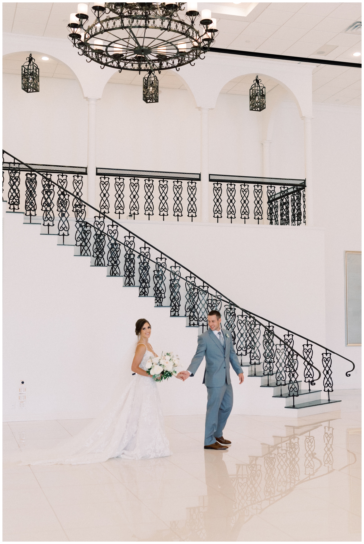 bride and groom walking in front of a grand staircase in Houston Texas