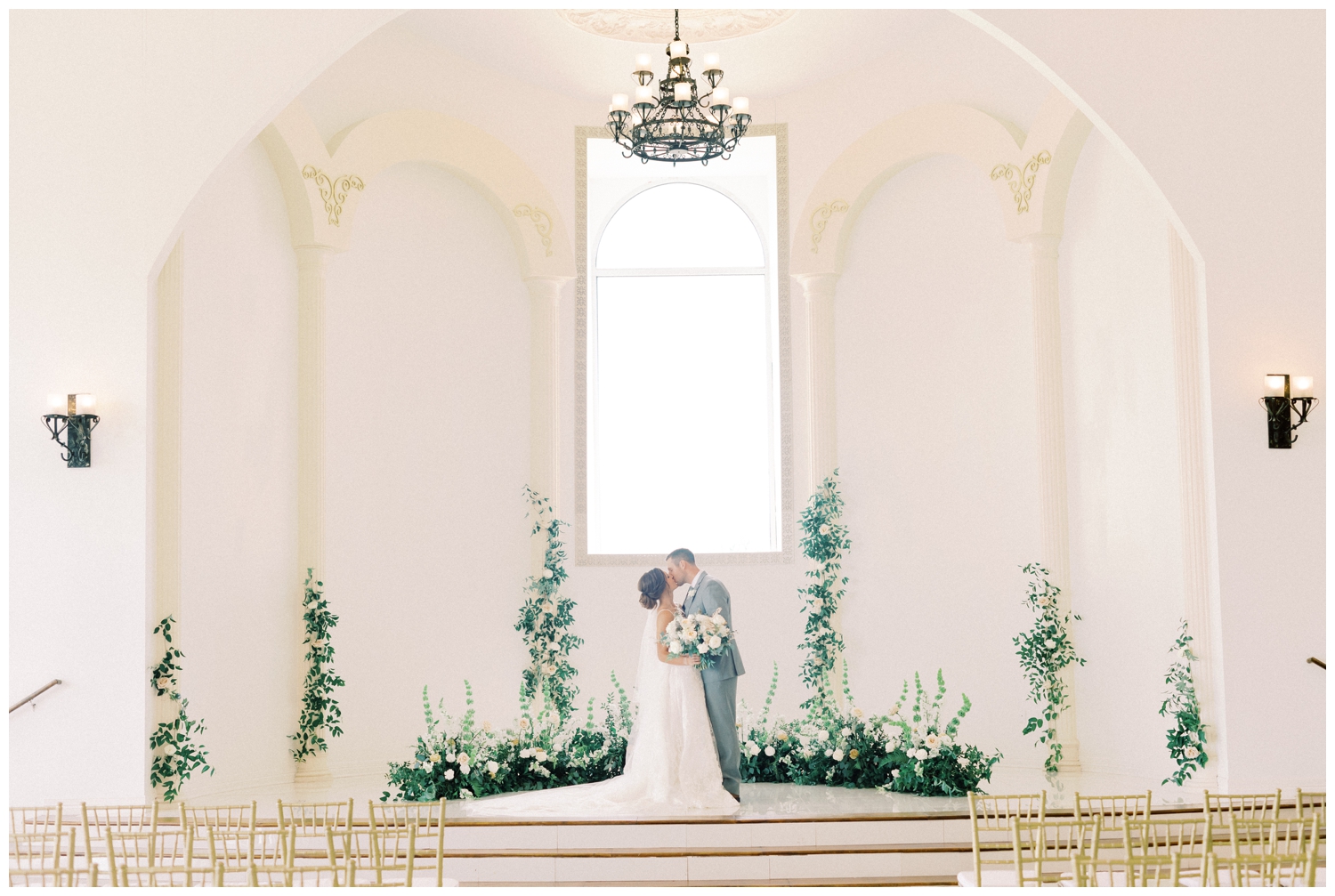 bride and groom kissing in floral ceremony space in Houston