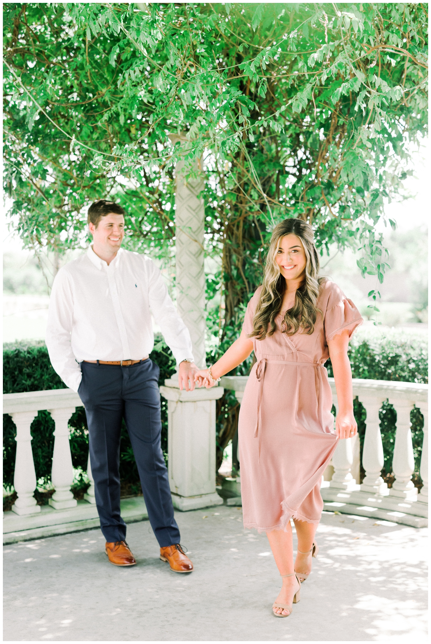 engaged couple walking toward camera outdoors under a tree at wedding venue Citadel Houston