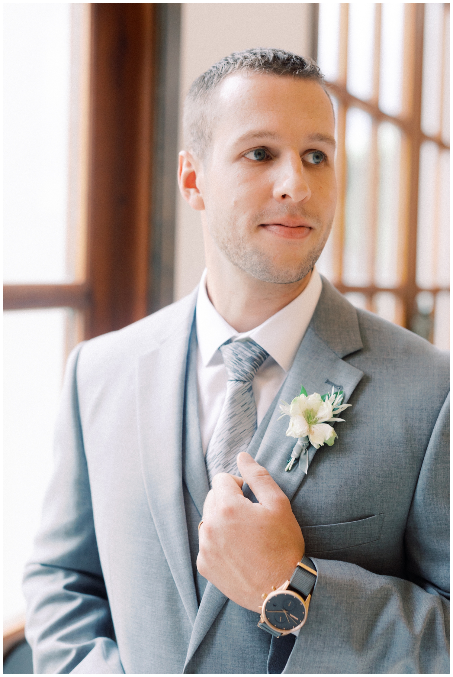 groom posing on with lapel of jacket