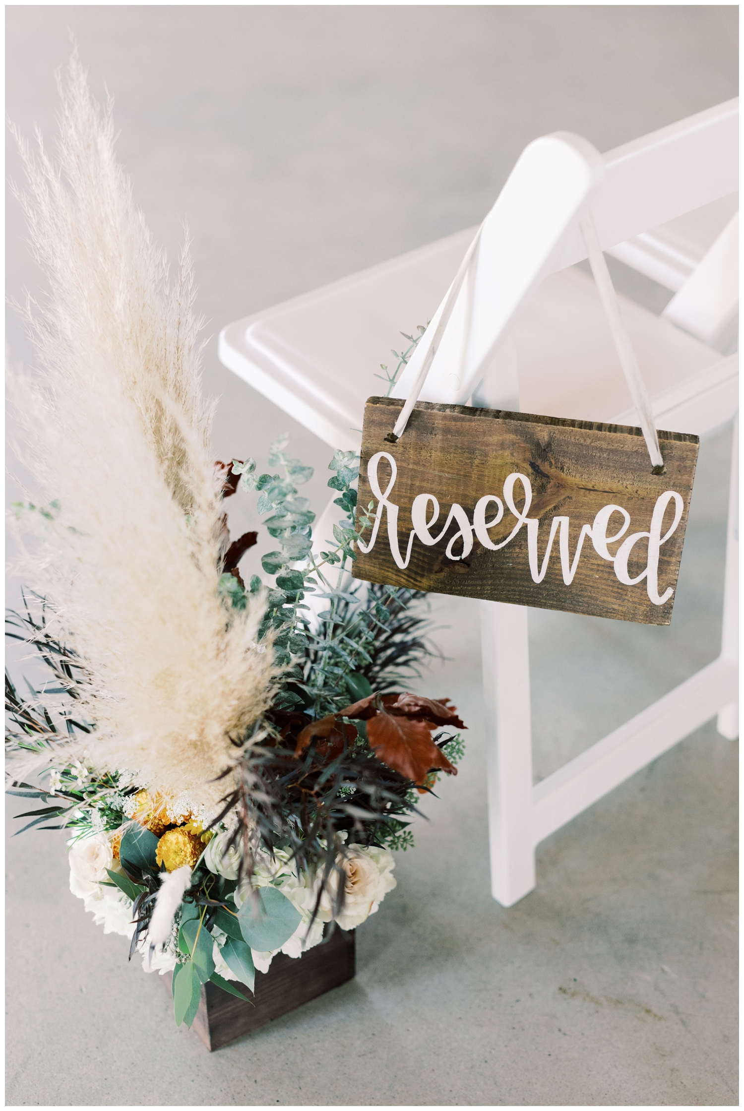 white pew with reserved sign and floral decor