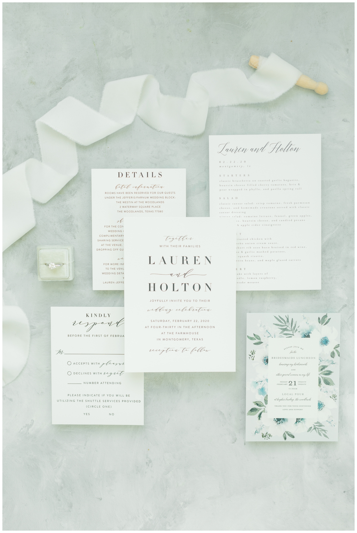 all white invitation suite flatlay with white ribbon