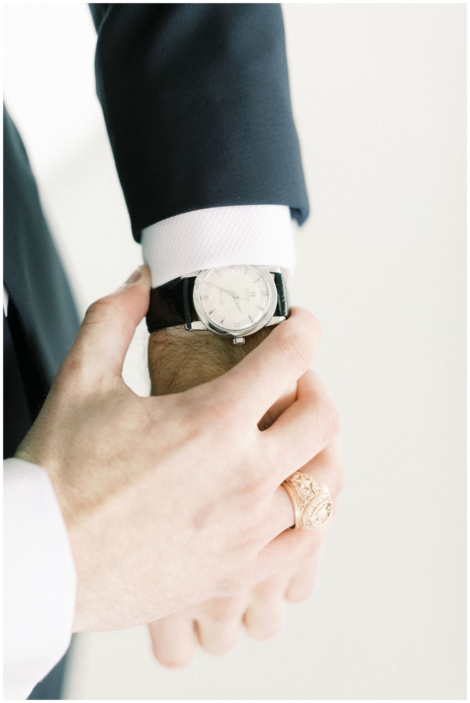 groom holding his watch on wedding day