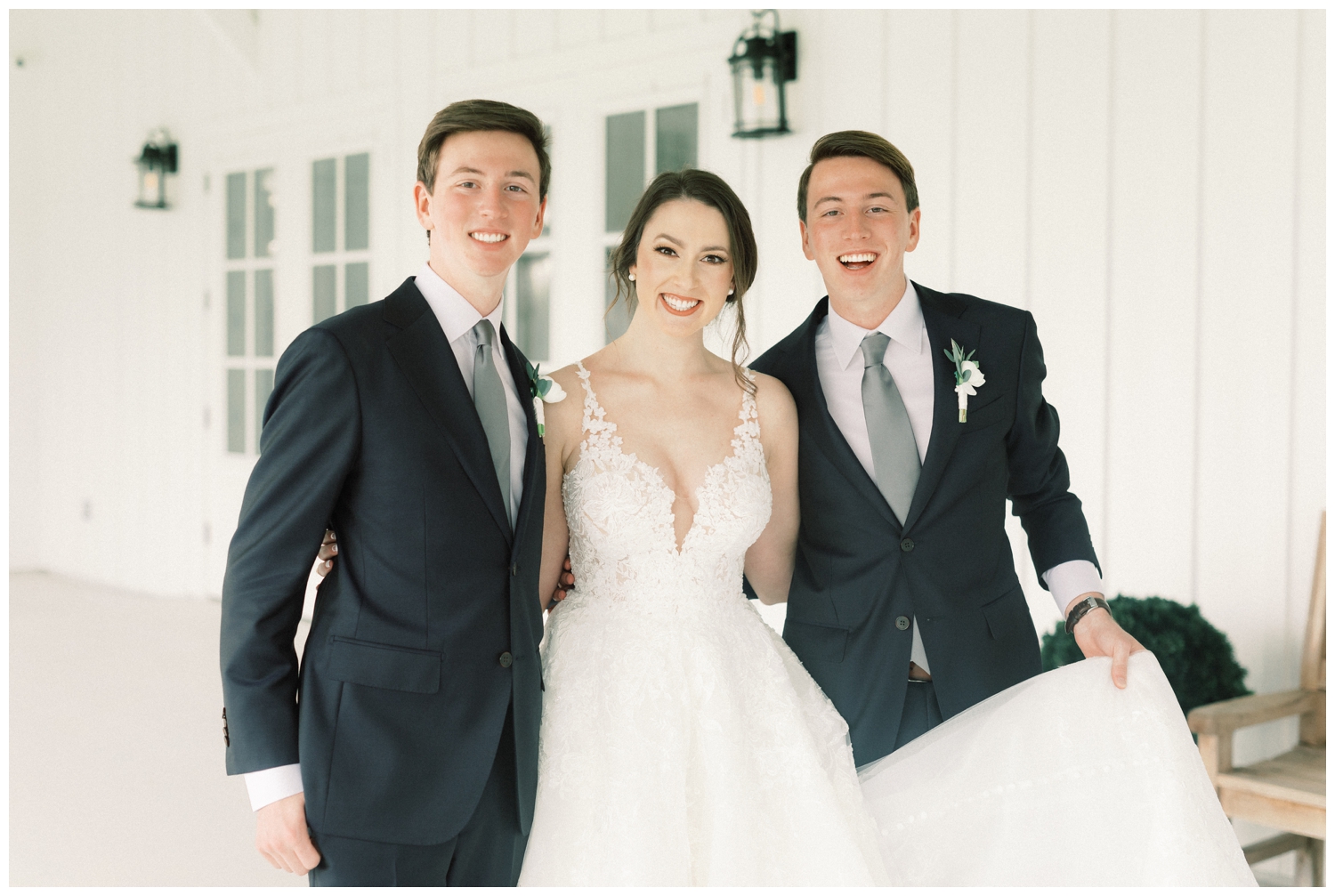 bride posing with twin brothers on wedding day