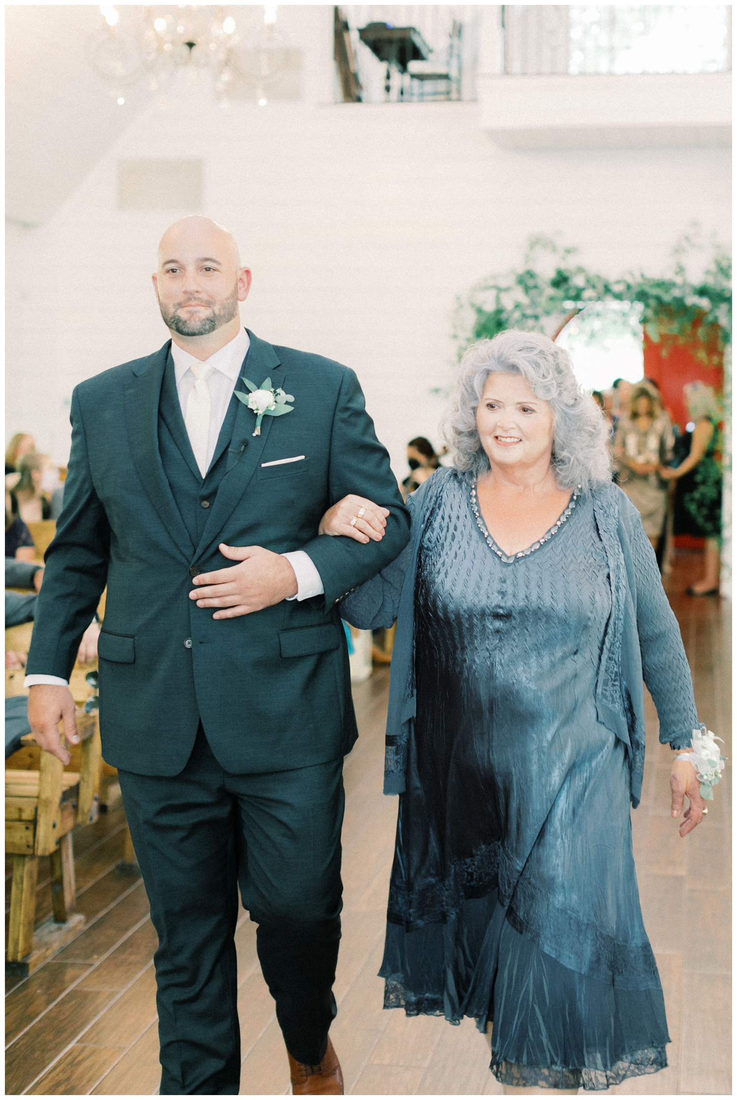 portrait-of-groom-walking-his-mother-down-the-aisle-wedding
