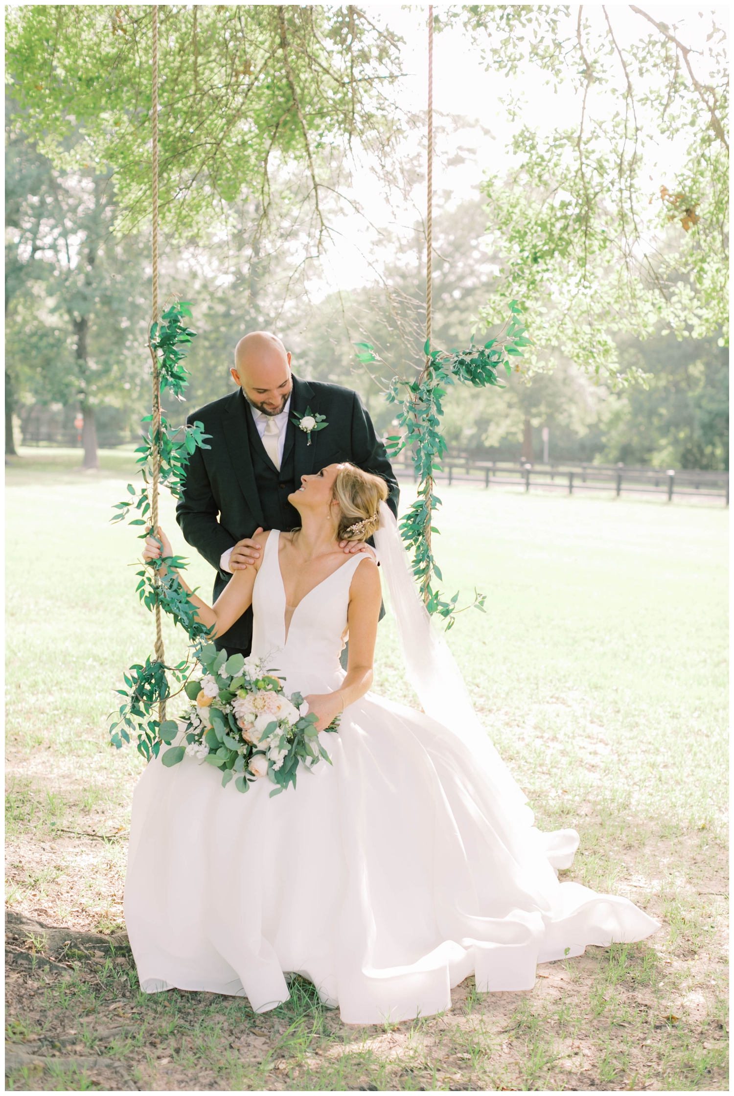 bride-looking-at-groom-on-swing-in-a-field