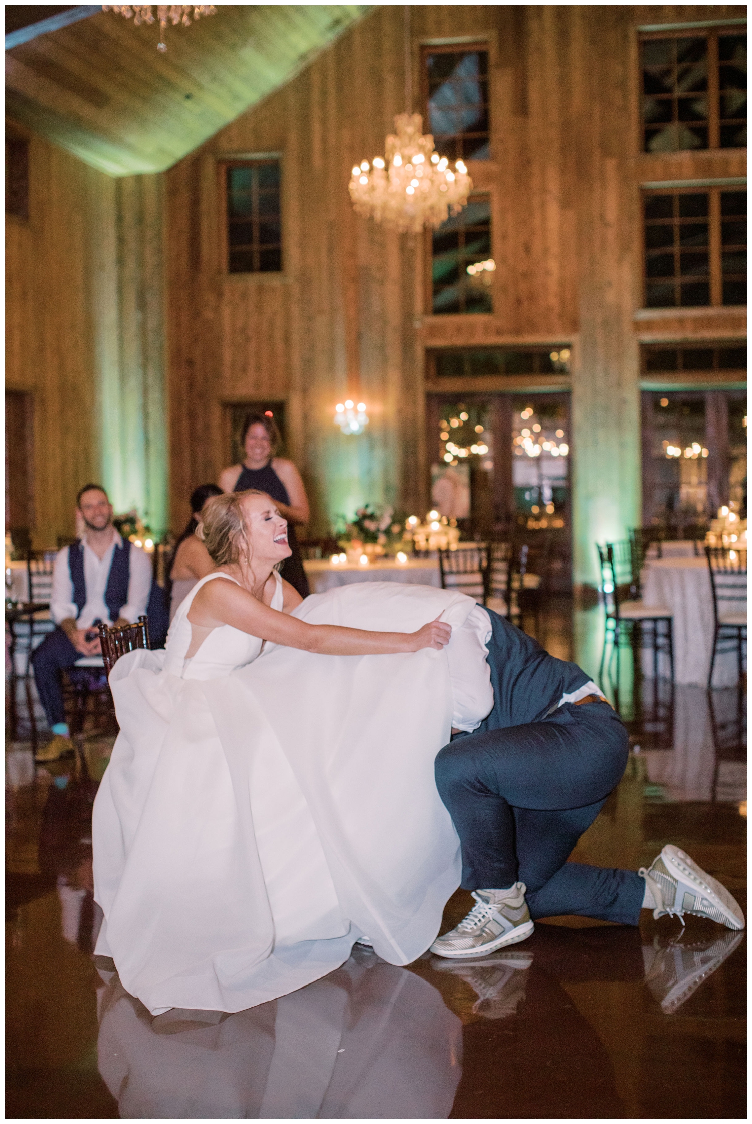 groom-getting-garter-from brides-dress