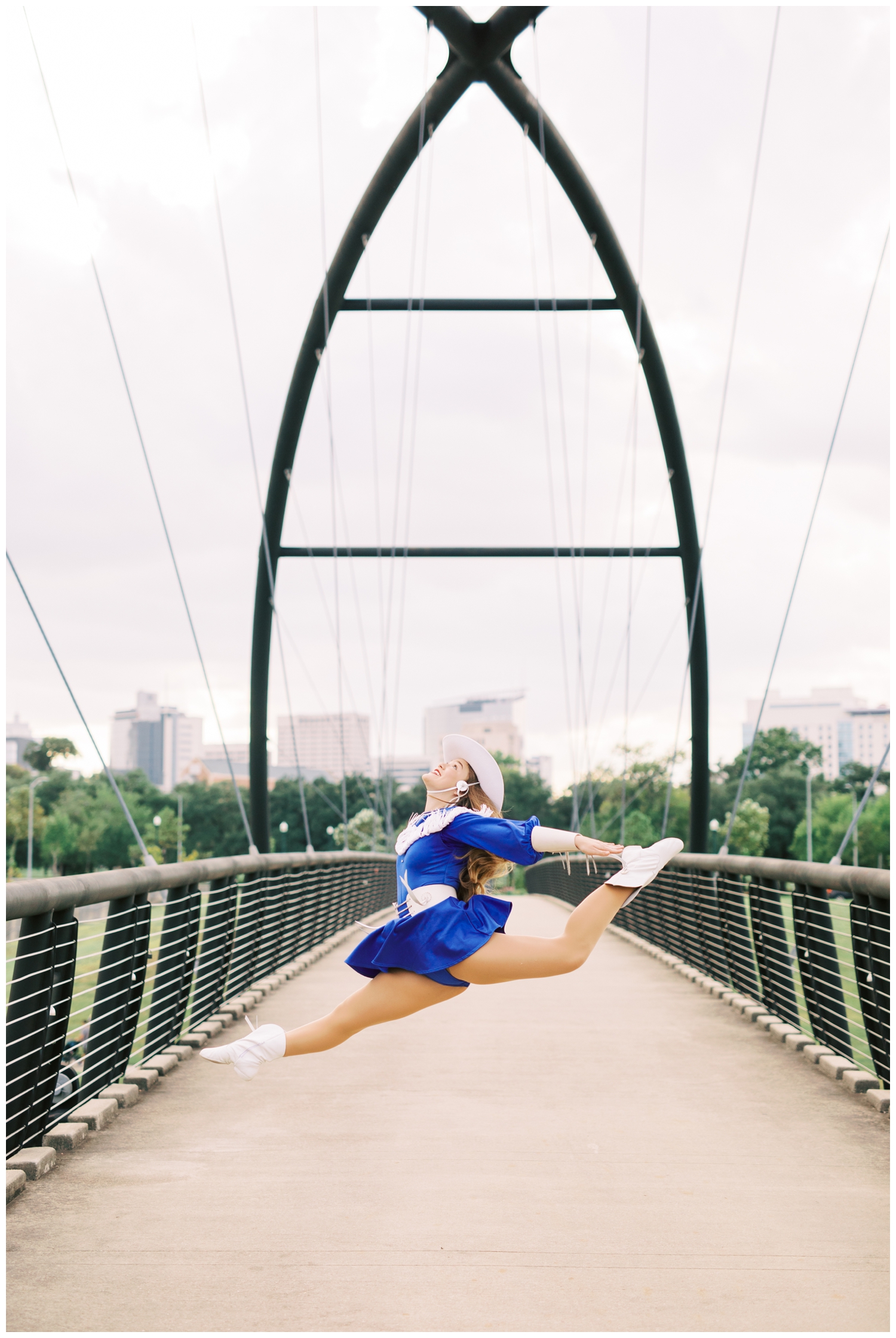 senior jumping dance pose on a bridge