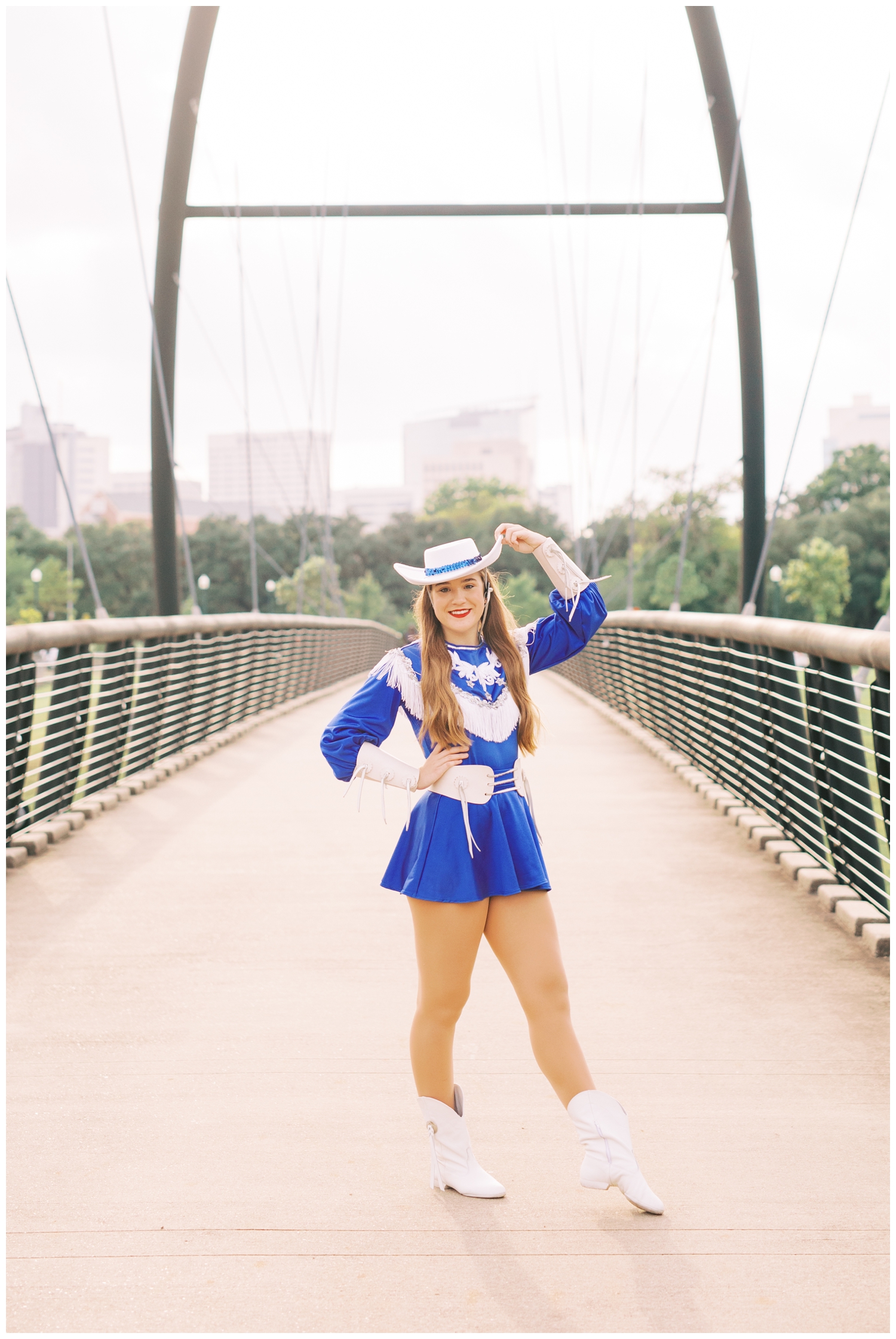 drill team dancer posing on a bridge with hand on hat at Hermann ParkHouston