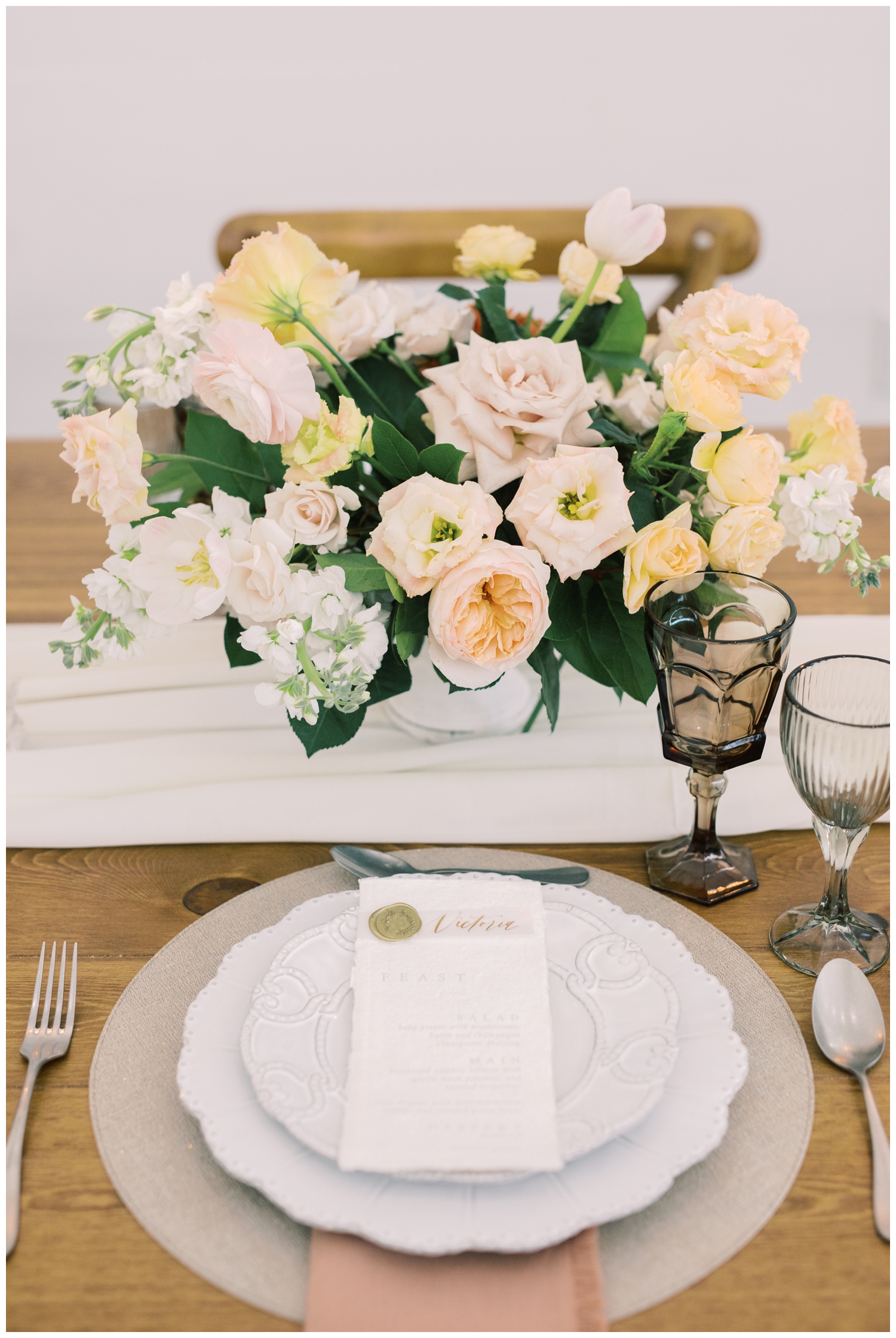 place setting for wedding reception with menu card and florals