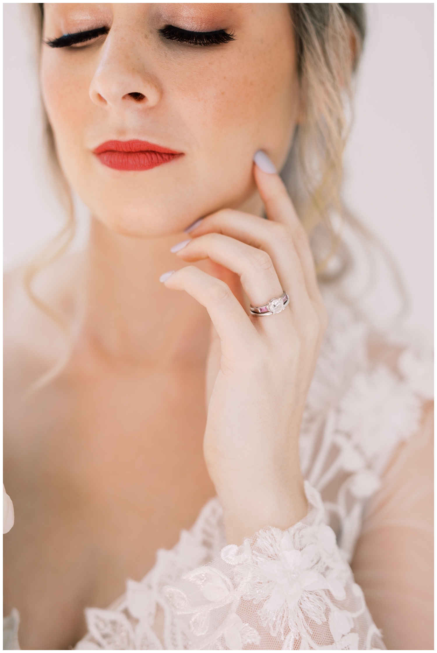 editorial bride holding finger with wedding ring near her face