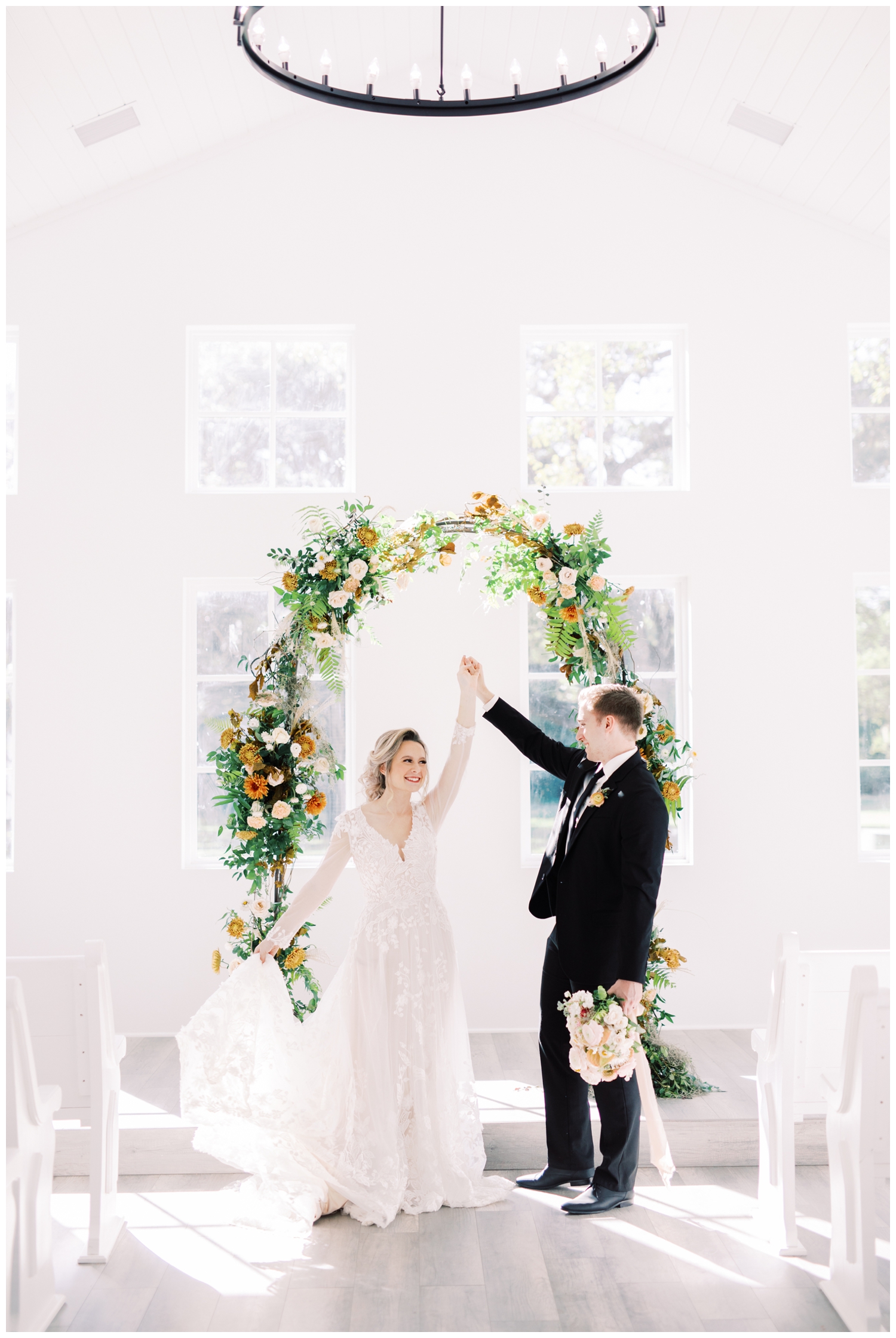 Addison Woods bride and groom dancing in the chapel by a floral arch