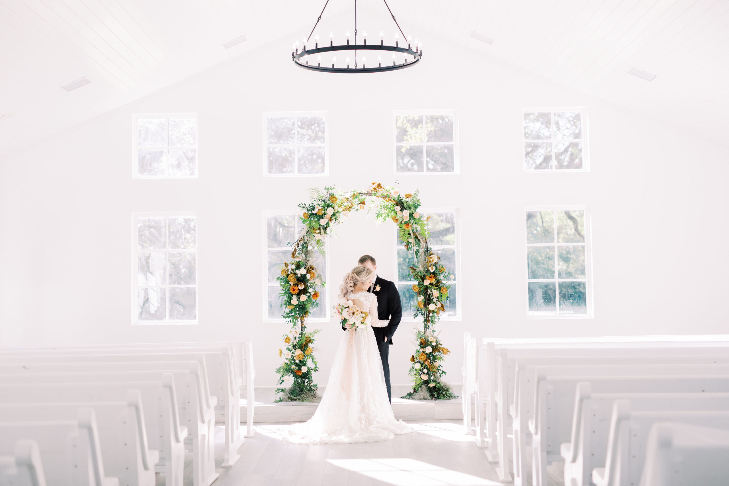 Bride and groom at Addison Woods Chapel under floral arch