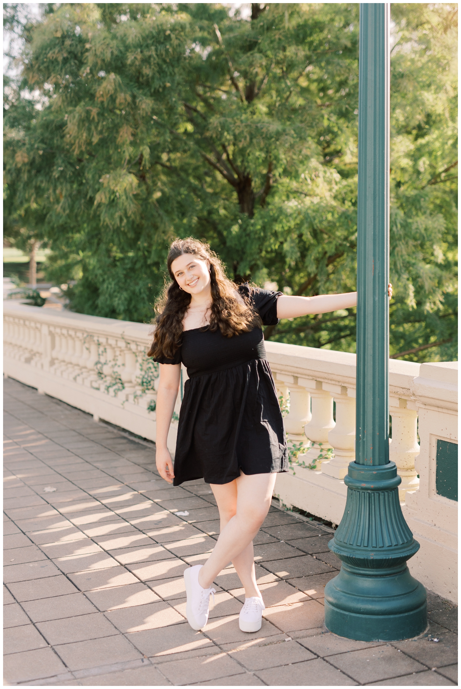senior girl leaning on lamp post at Buffalo Bayou Park in Houston with Reed Gallagher Photography