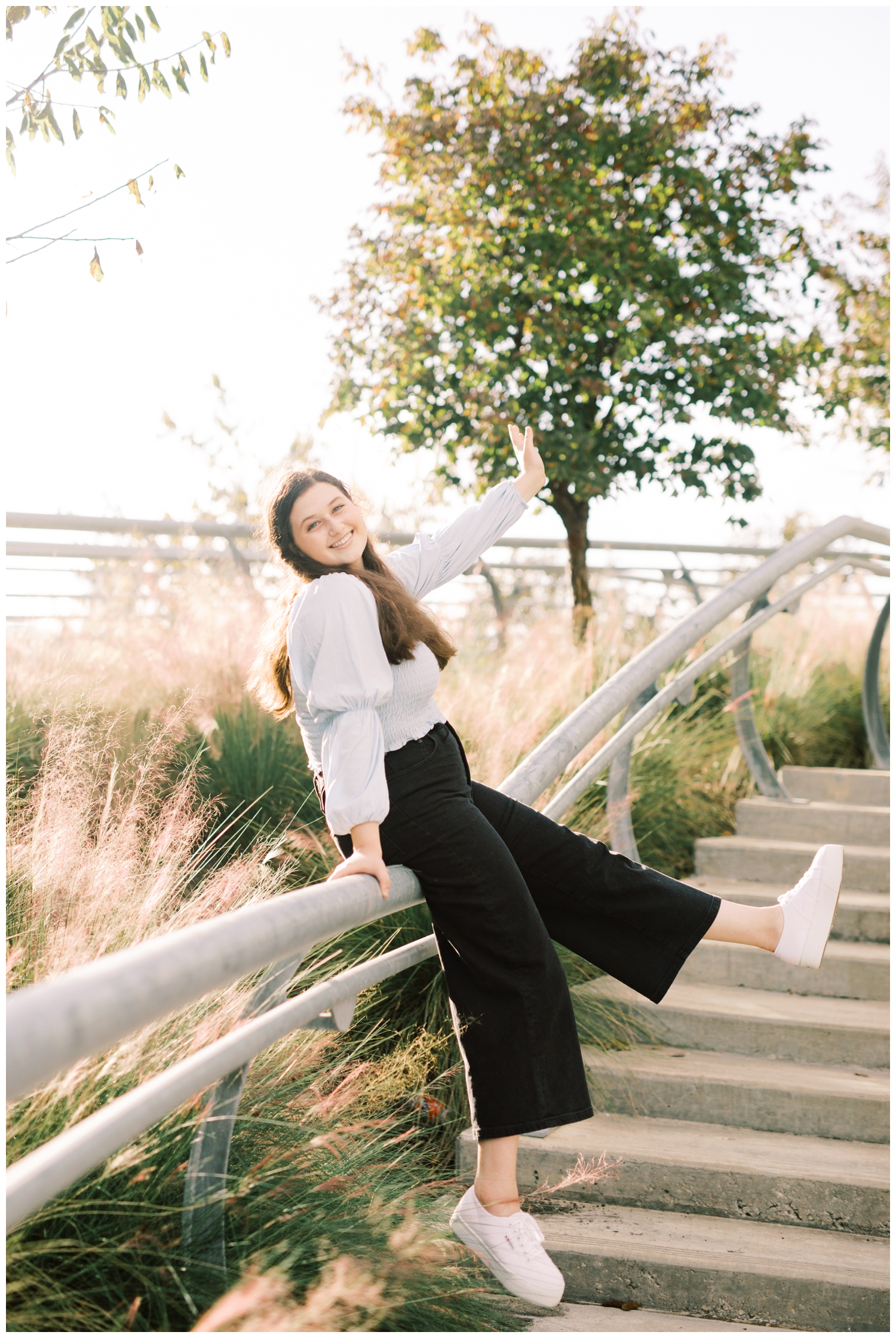 Senior girl kicking her leg during senior portrait session at Buffalo Bayou Park with Reed Gallagher Photography