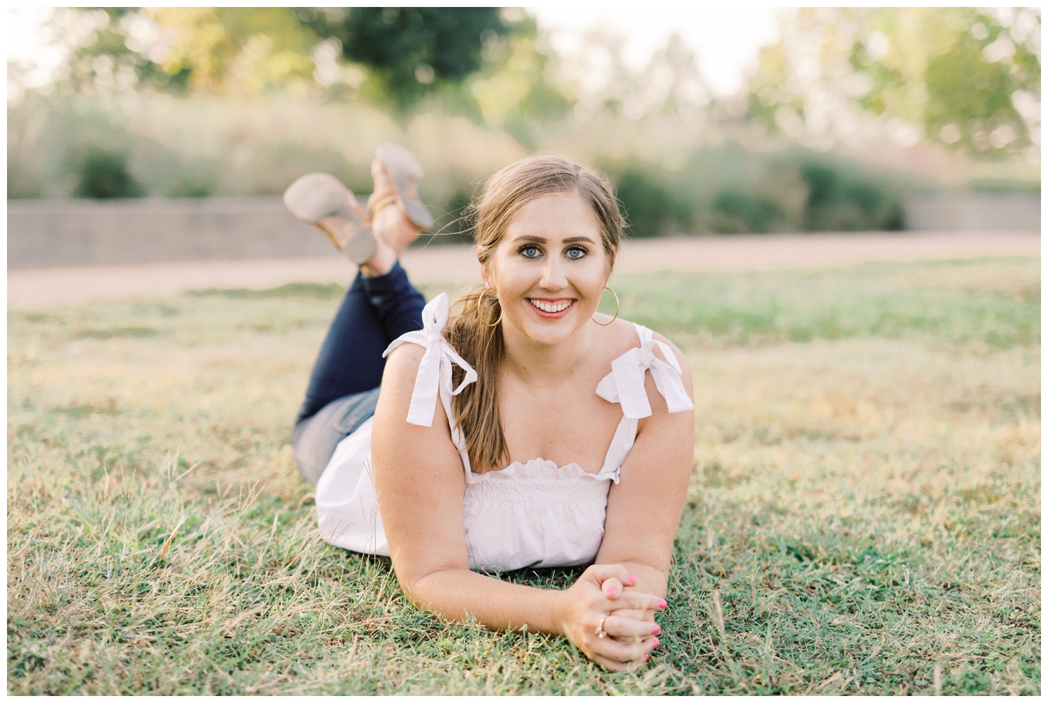 girl laying down on grass for senior session with Reed Gallagher Photography