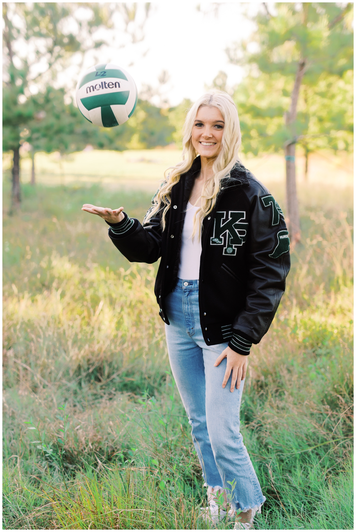 girl throwing a volleyball for her senior portrait session at Eleanor Tinsley Park with a Houston Senior Photographer