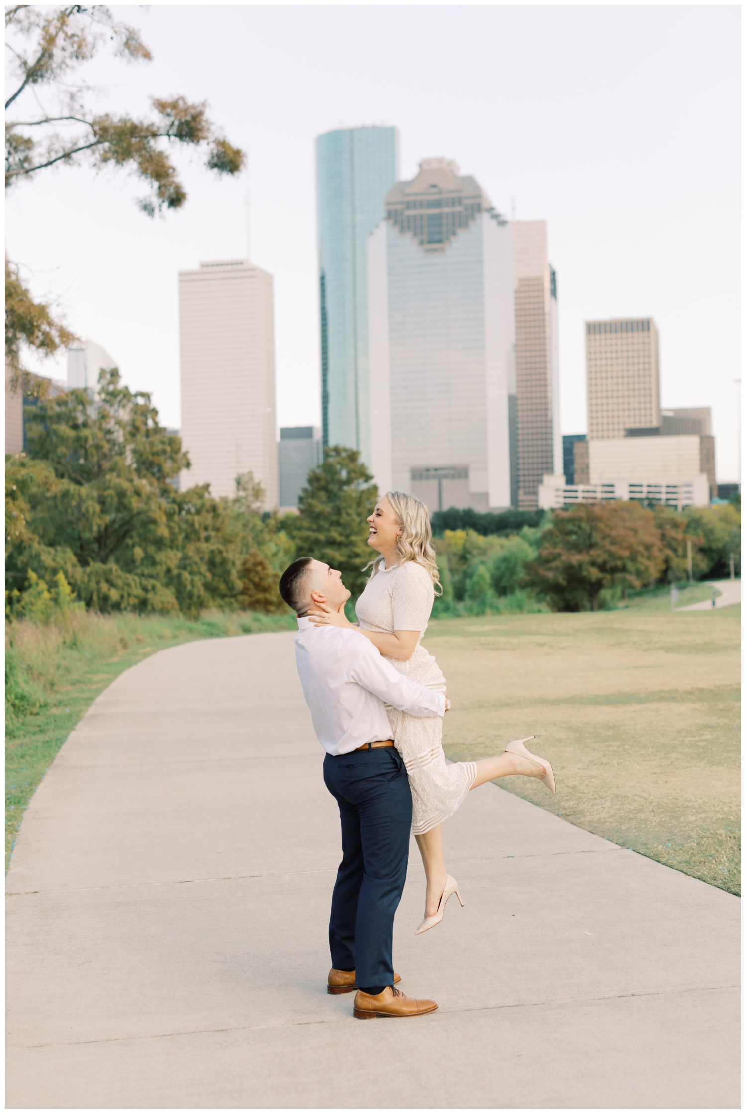 engaged couple posing in front of the downtown Houston skyline