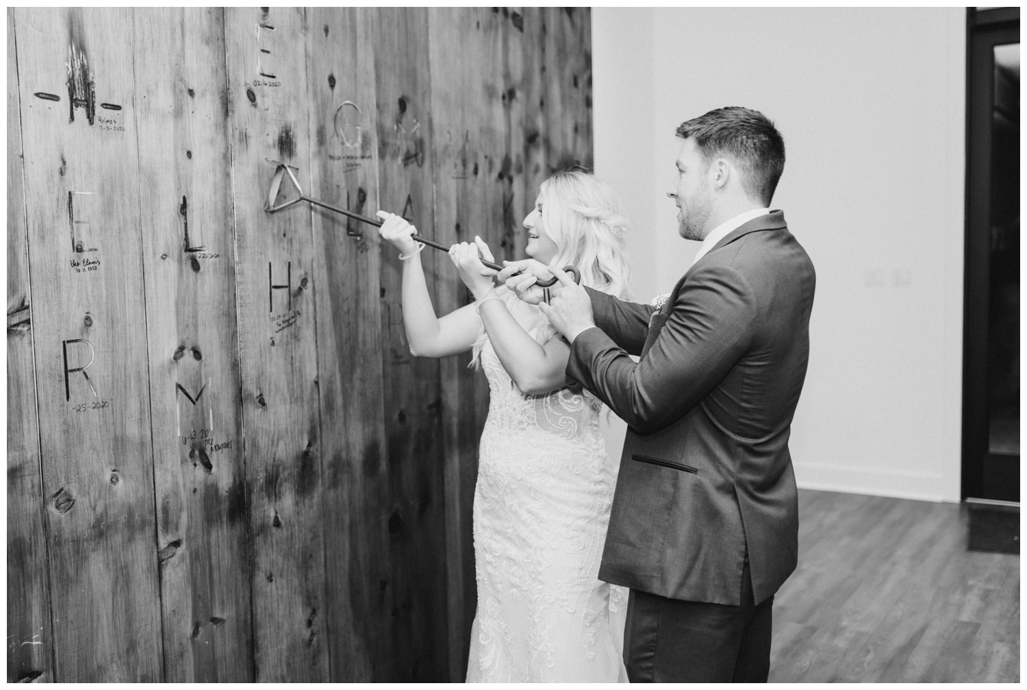 bride and groom leaving branding mark on wall at Deep In The Heart Farms