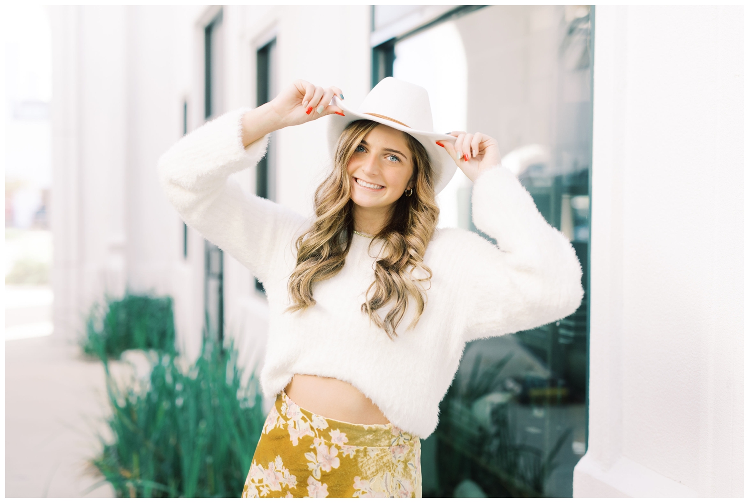 senior rep posing with white hat and floral skirt in Houston, Texas