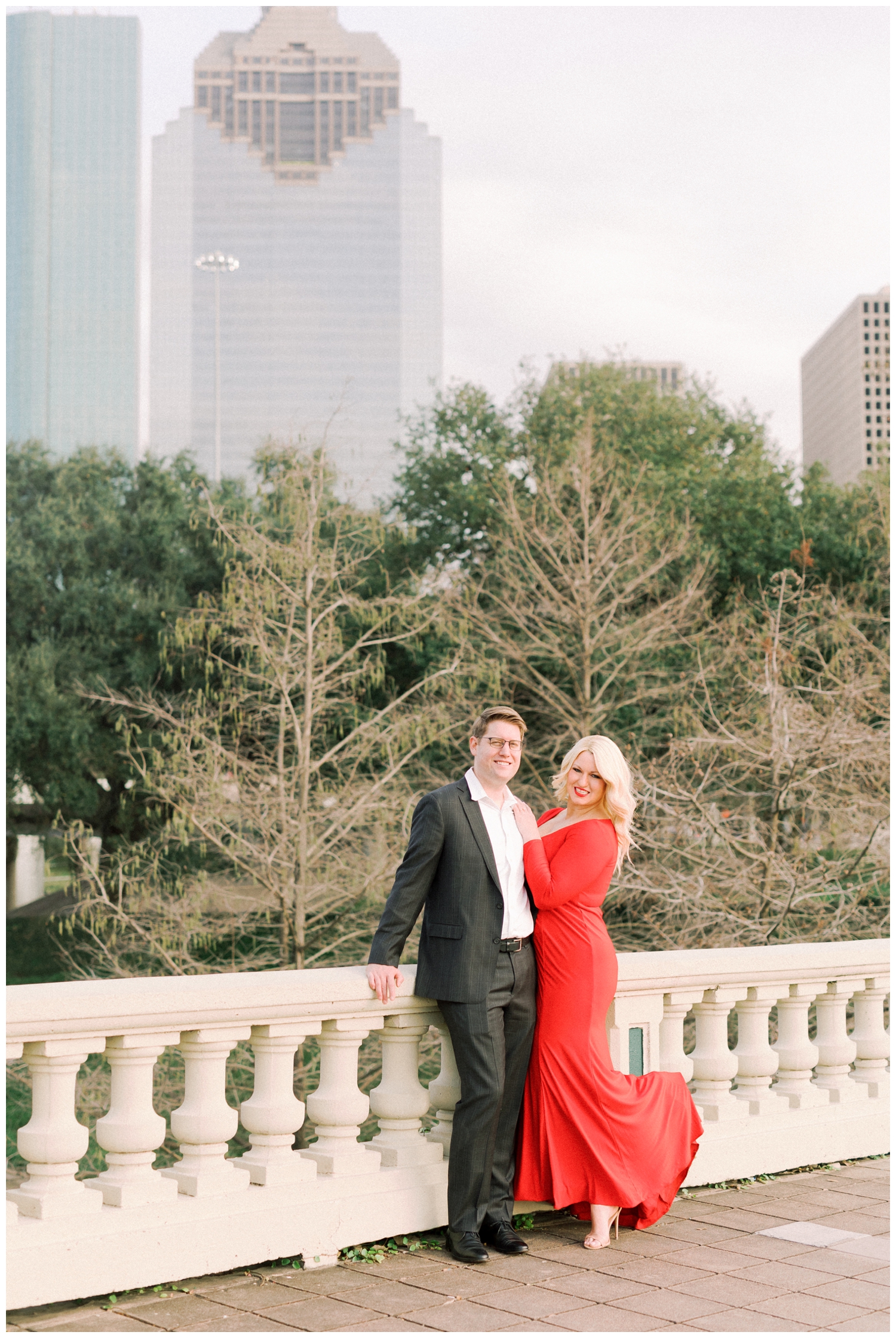 engaged couple posing on Sabine Bridge in front of Houston skyline