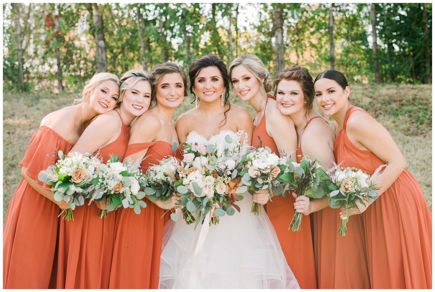 rust colored bridesmaid dresses with white bouquets
