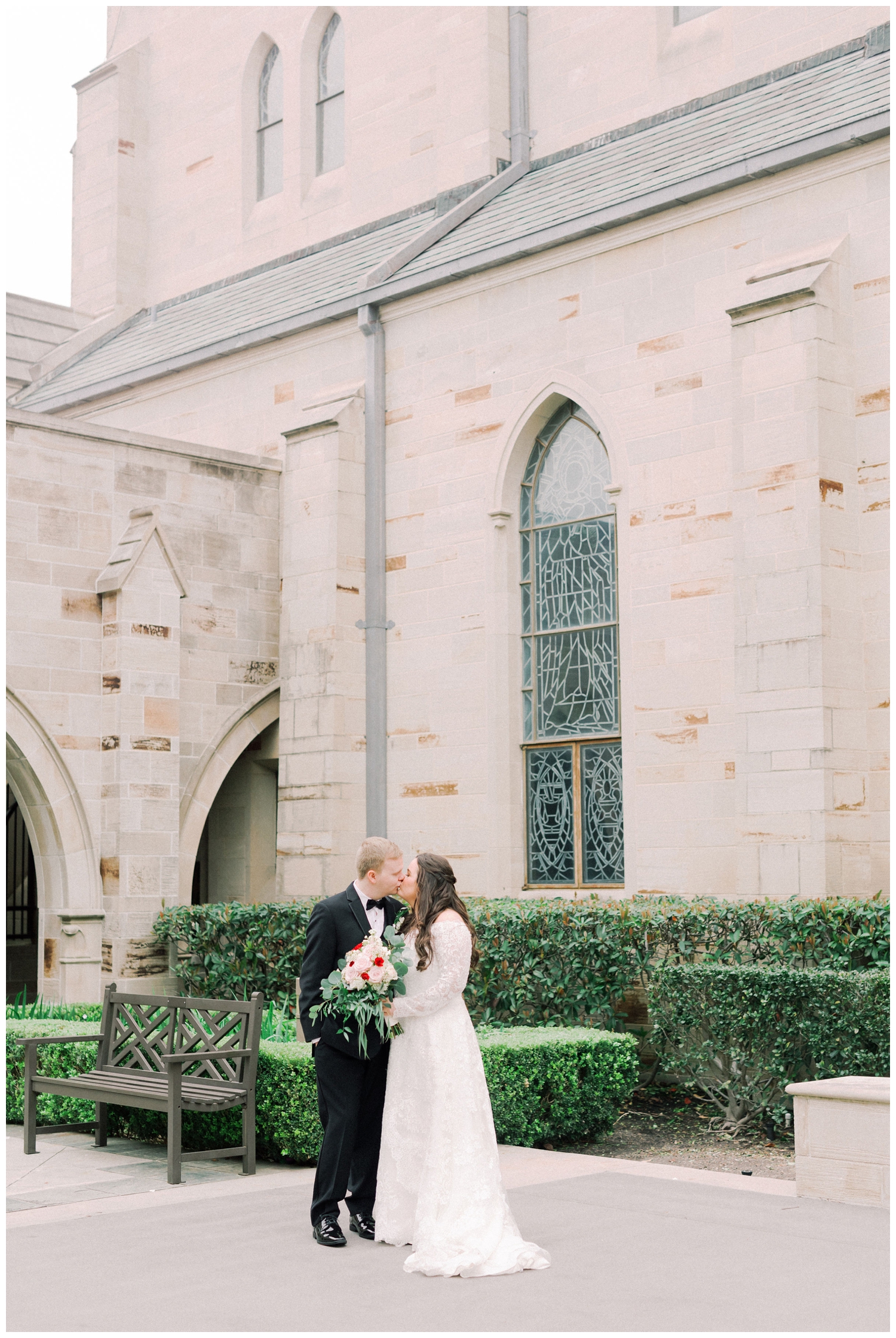 bride and groom kissing outside Holy Rosary Church in Houston, Texas