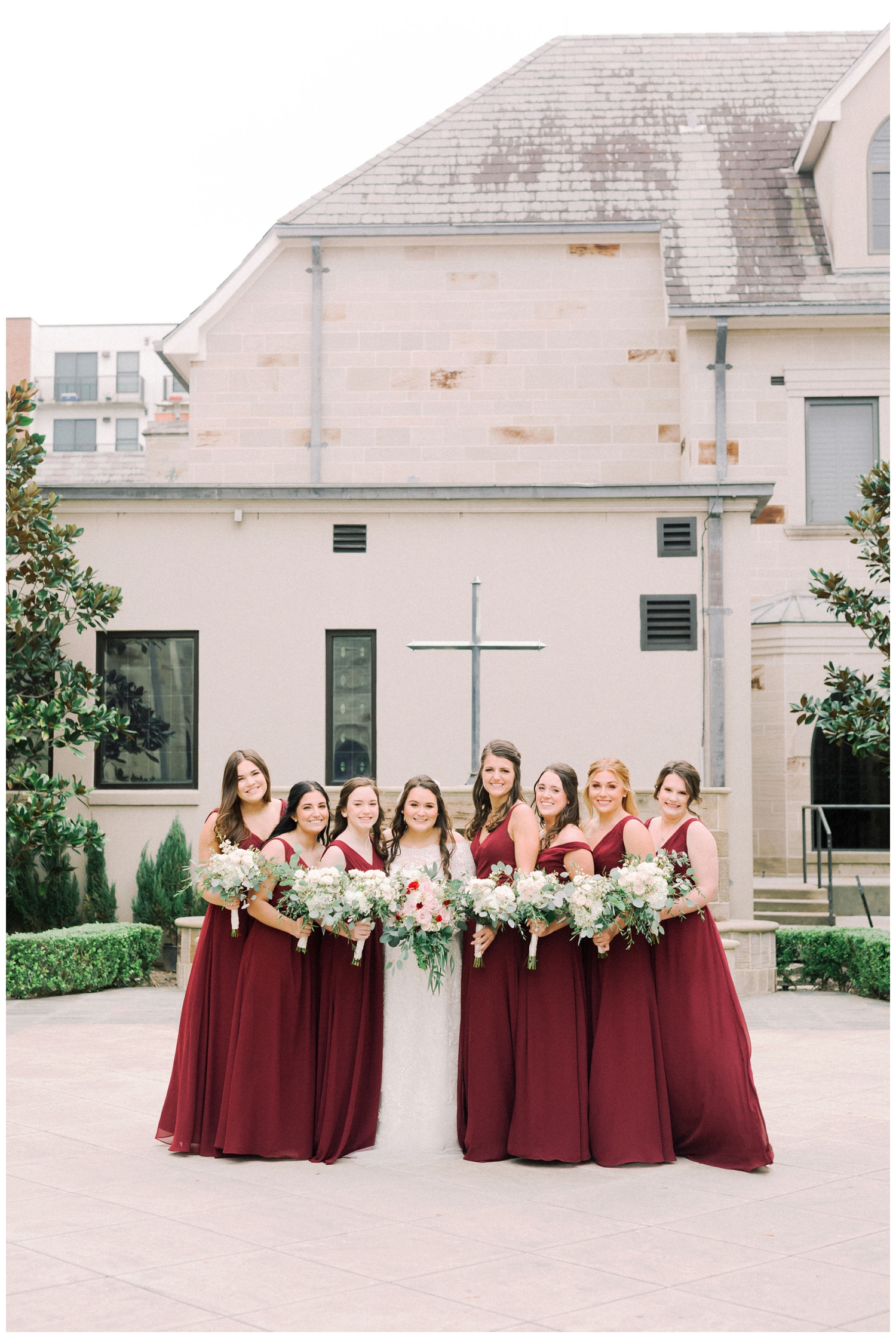 bridal party in wine bridesmaid dresses outside Holy Rosary Church
