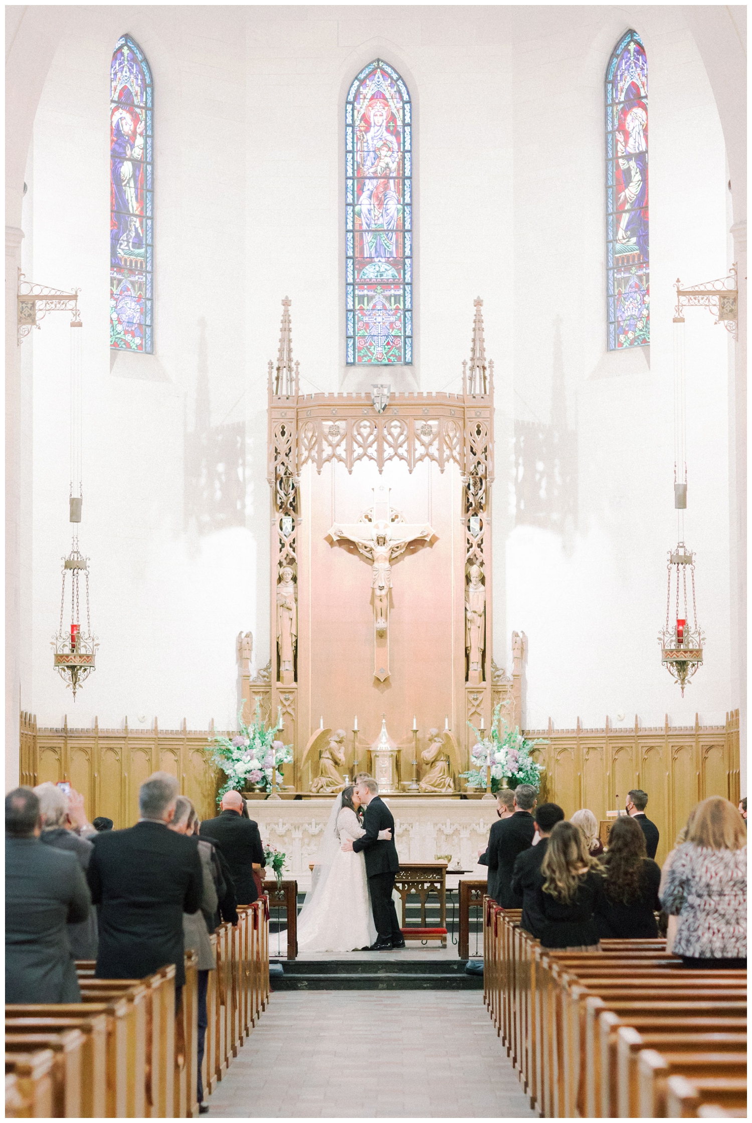 bride and groom kissing during ceremony inside Holy Rosary church