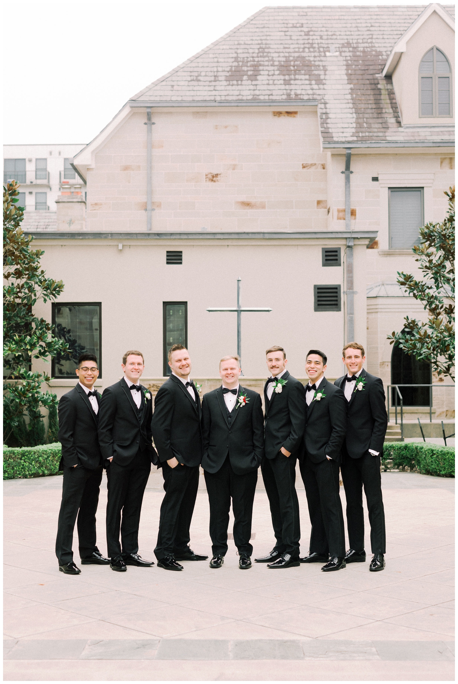 groom with groomsmen posing outside Holy Rosary Church