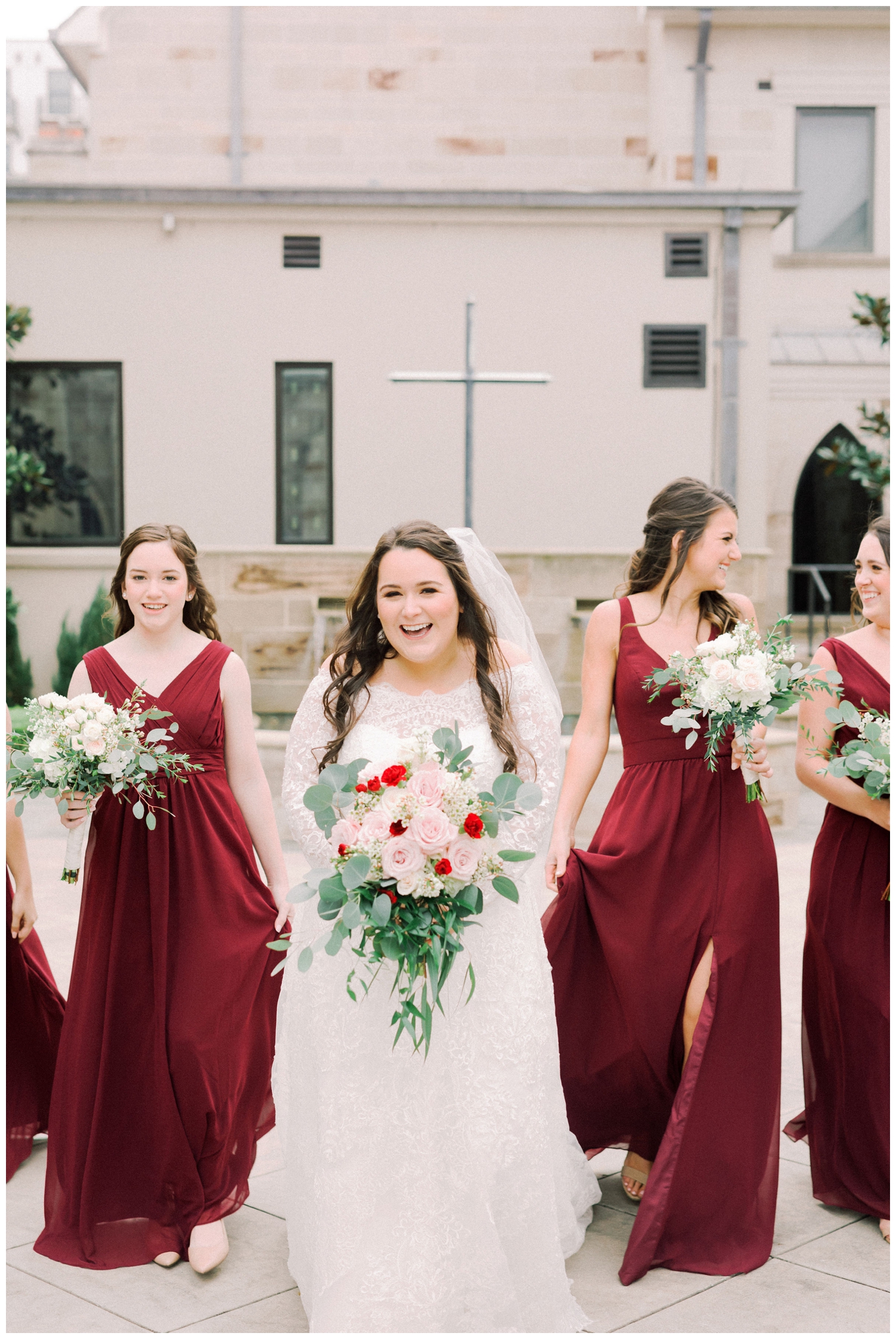 bride laughing with bridesmaids outside Holy Rosary Church in Houston, Texas