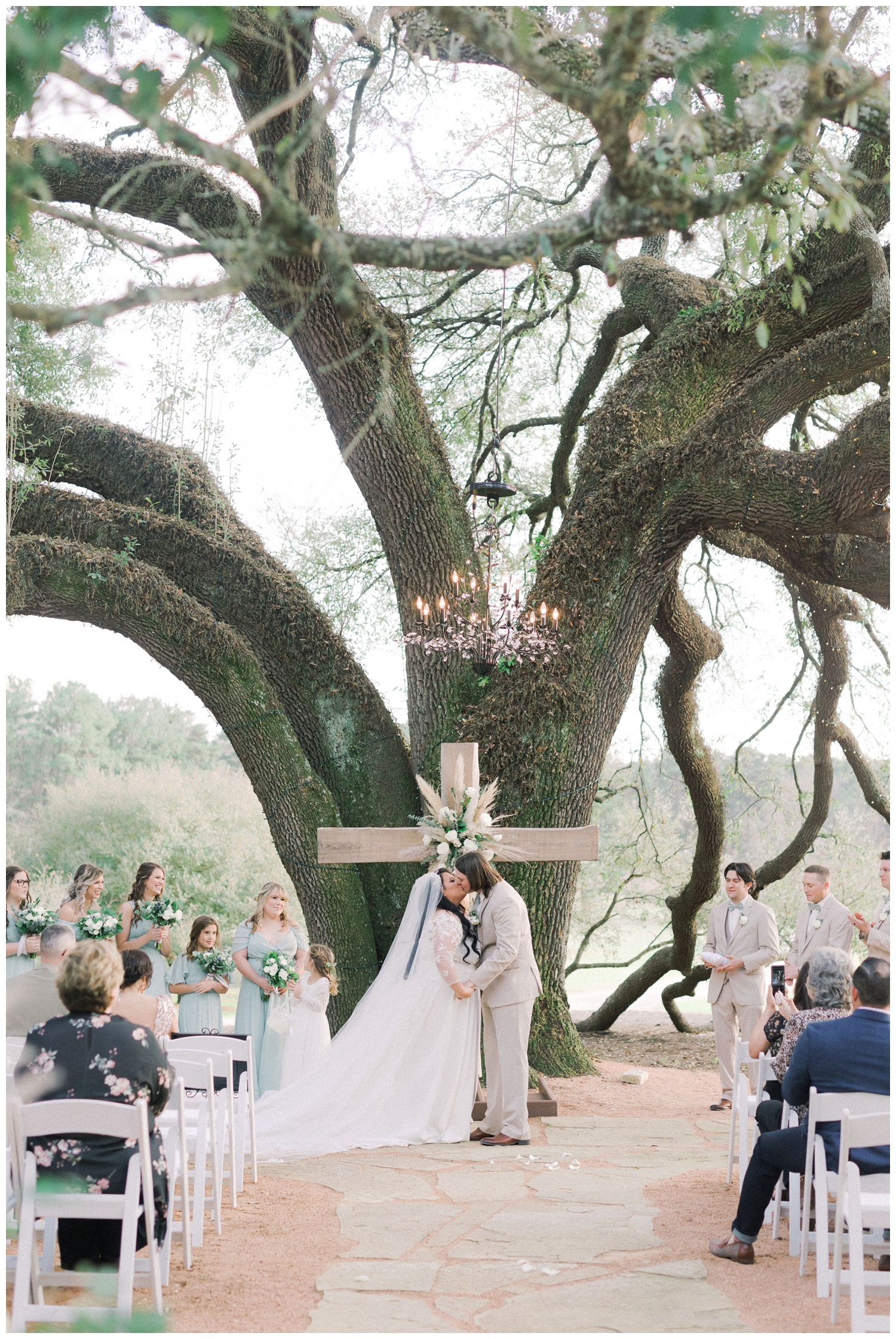 bride and groom kissing under oak tree