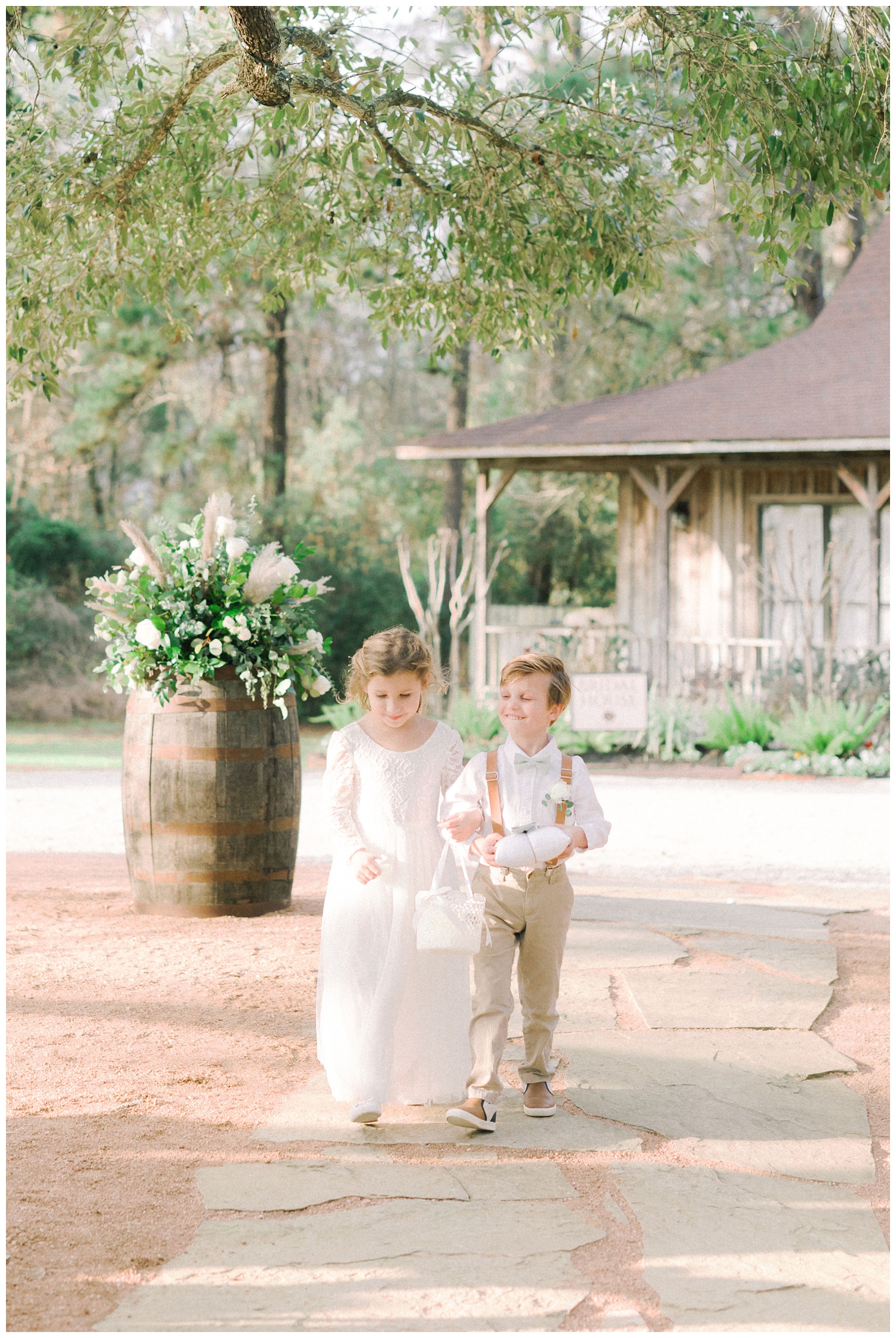 flower girl and ring bearer walking down the aisle at outdoor wedding