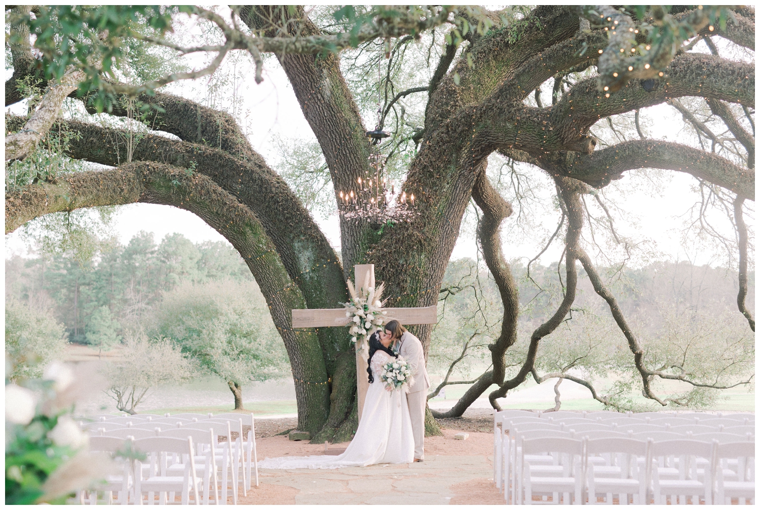 newlyweds kissing under live oak tree at Pine Lake Ranch