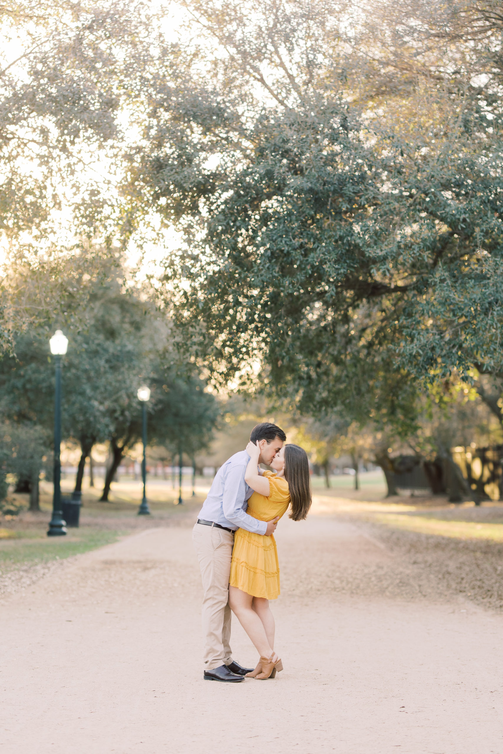 engaged couple kissing under the trees at Hermann Park