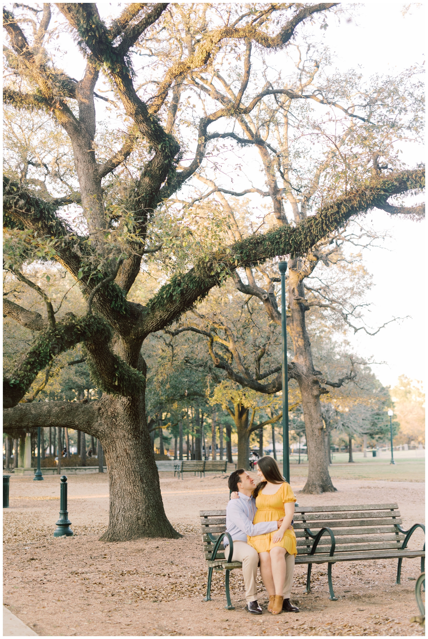 couple posing on park bench in Hermann Park for Houston engagement photographer