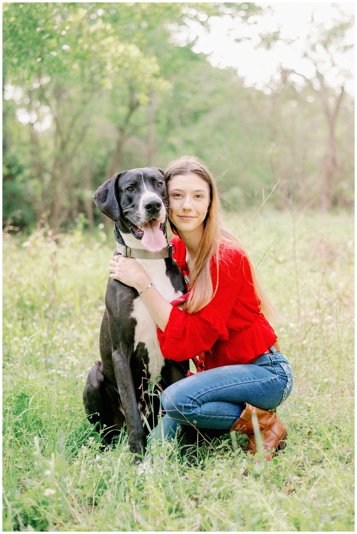 girl in a field kneeling and hugging her dog at Cy-Hope for a Cypress senior photographer