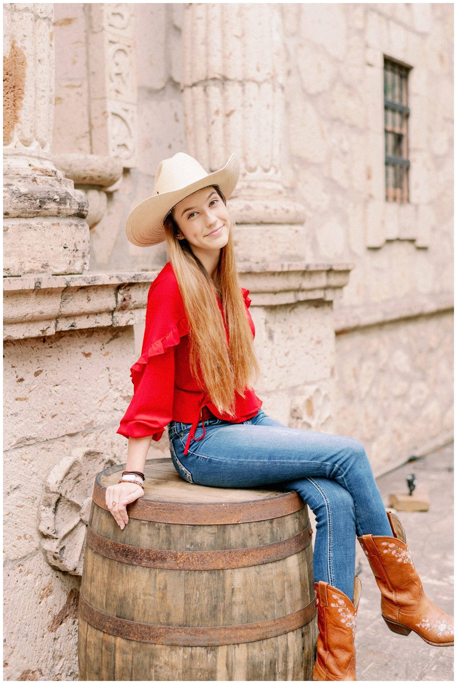 girl with boots and cowboy hat sitting on a barrel at Cy-Hope in Cypress, Texas