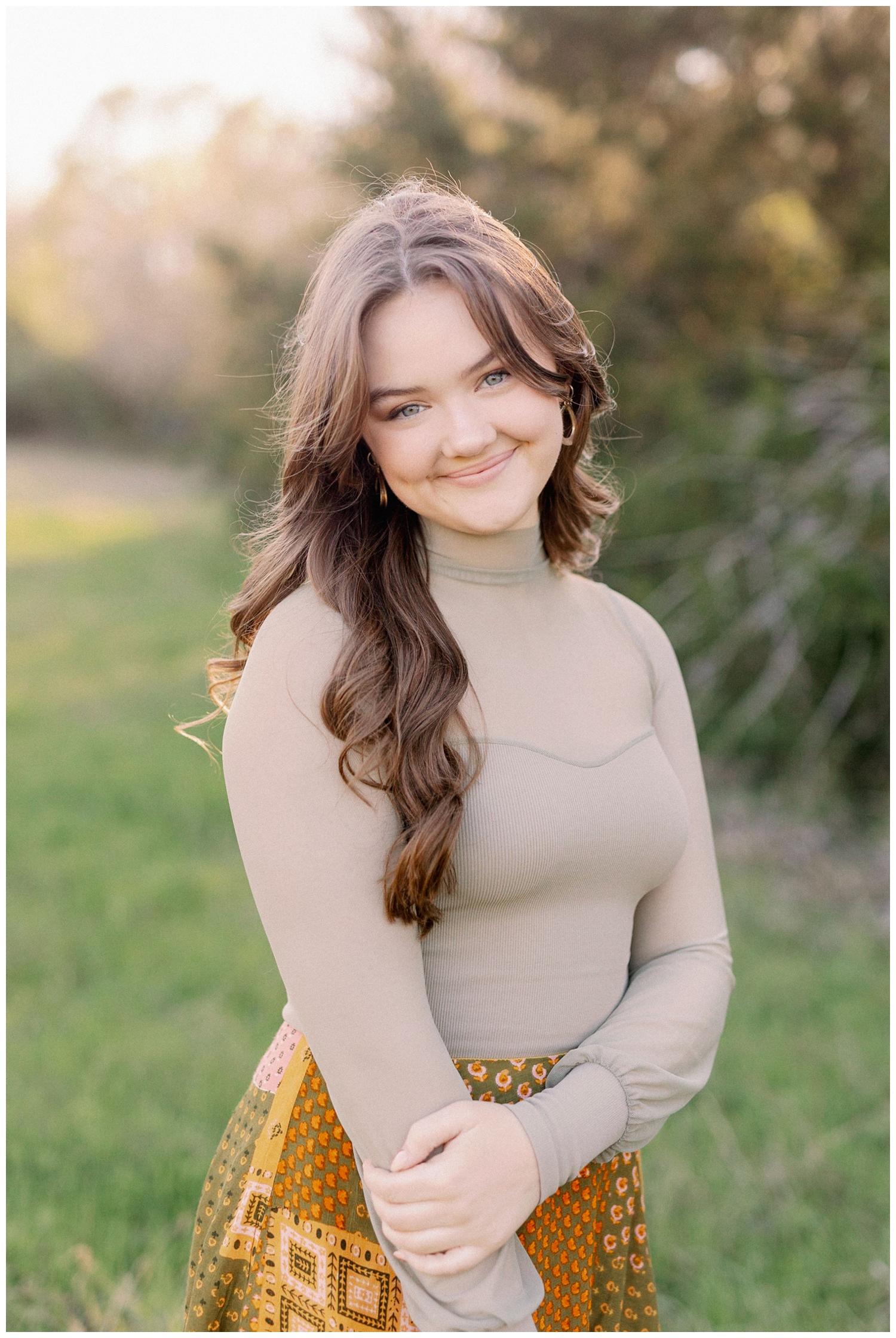 close up of a girl in front of a tree with arms crossed posing for a Houston Outdoor senior photographer