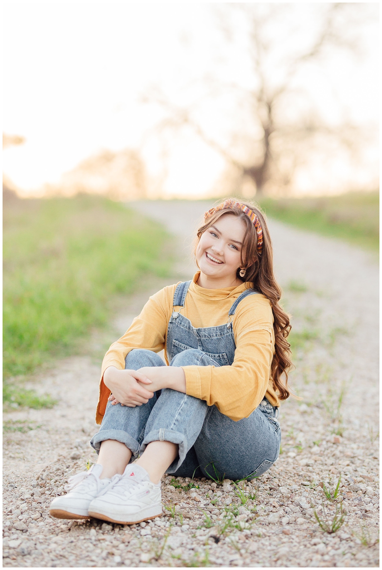 girl sitting on a pathway for a Houston outdoor senior photographer