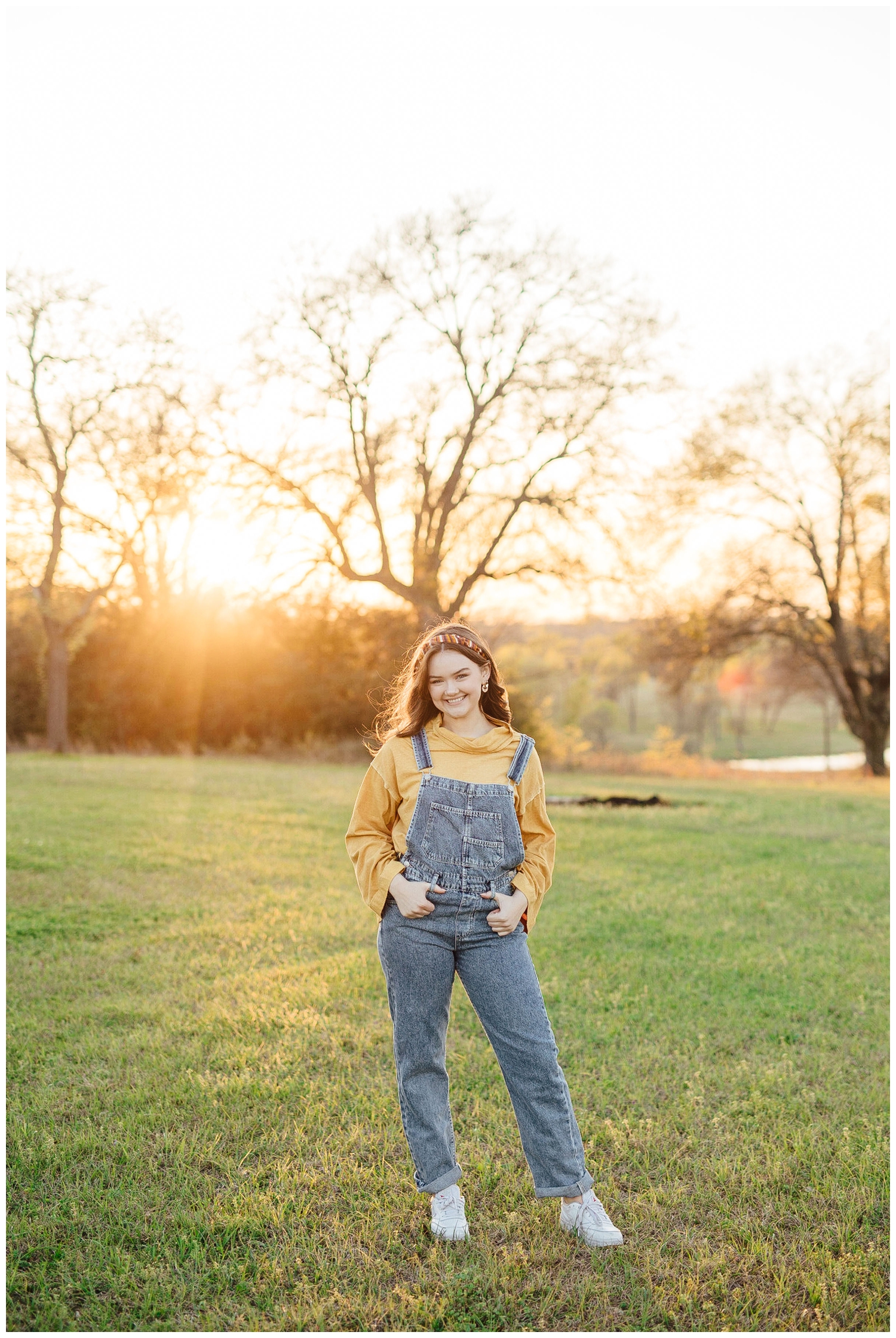 girl in overalls posing during sunset