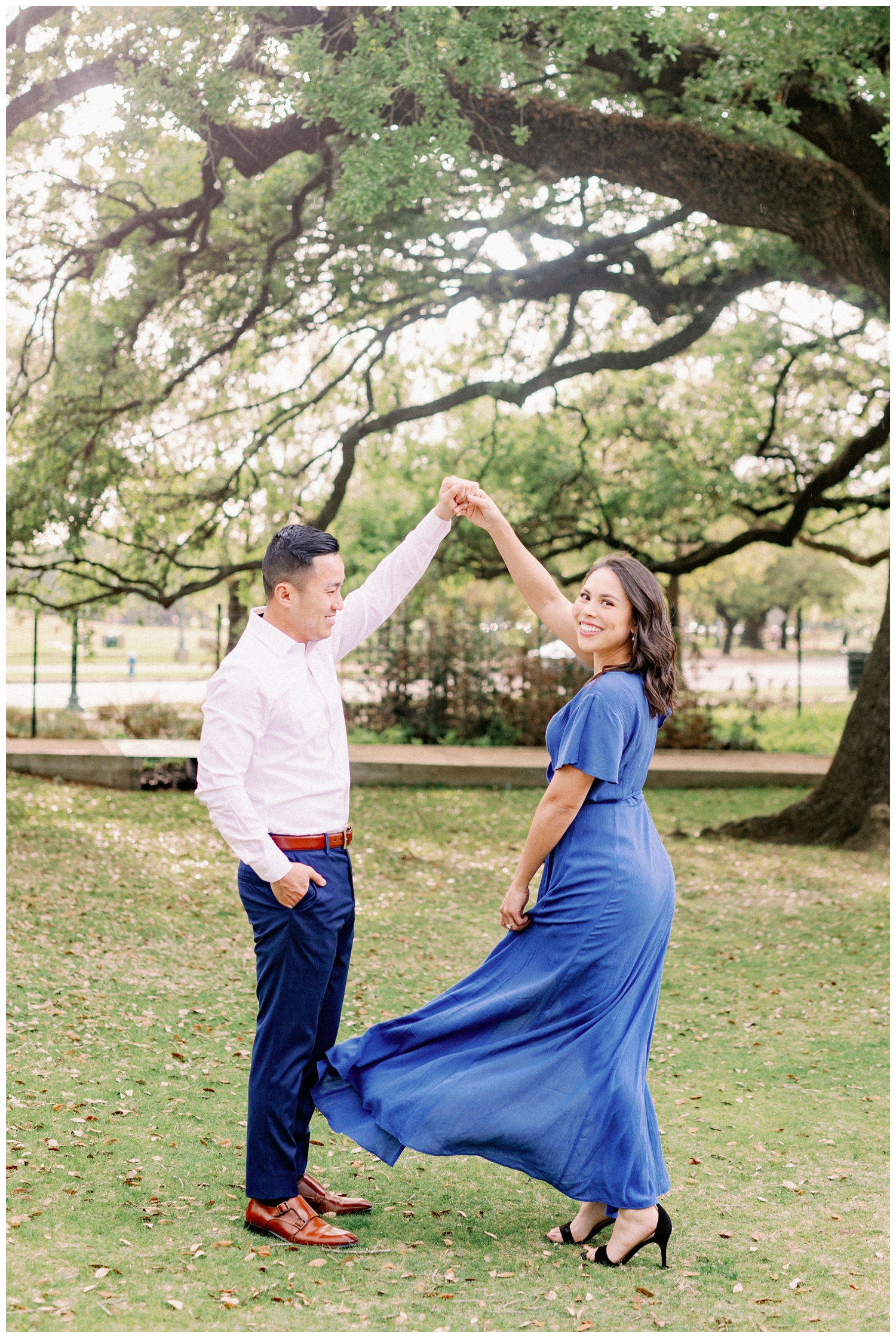 couple twirling on the lawn under a tree at McGovern Centennial Gardens engagement photos