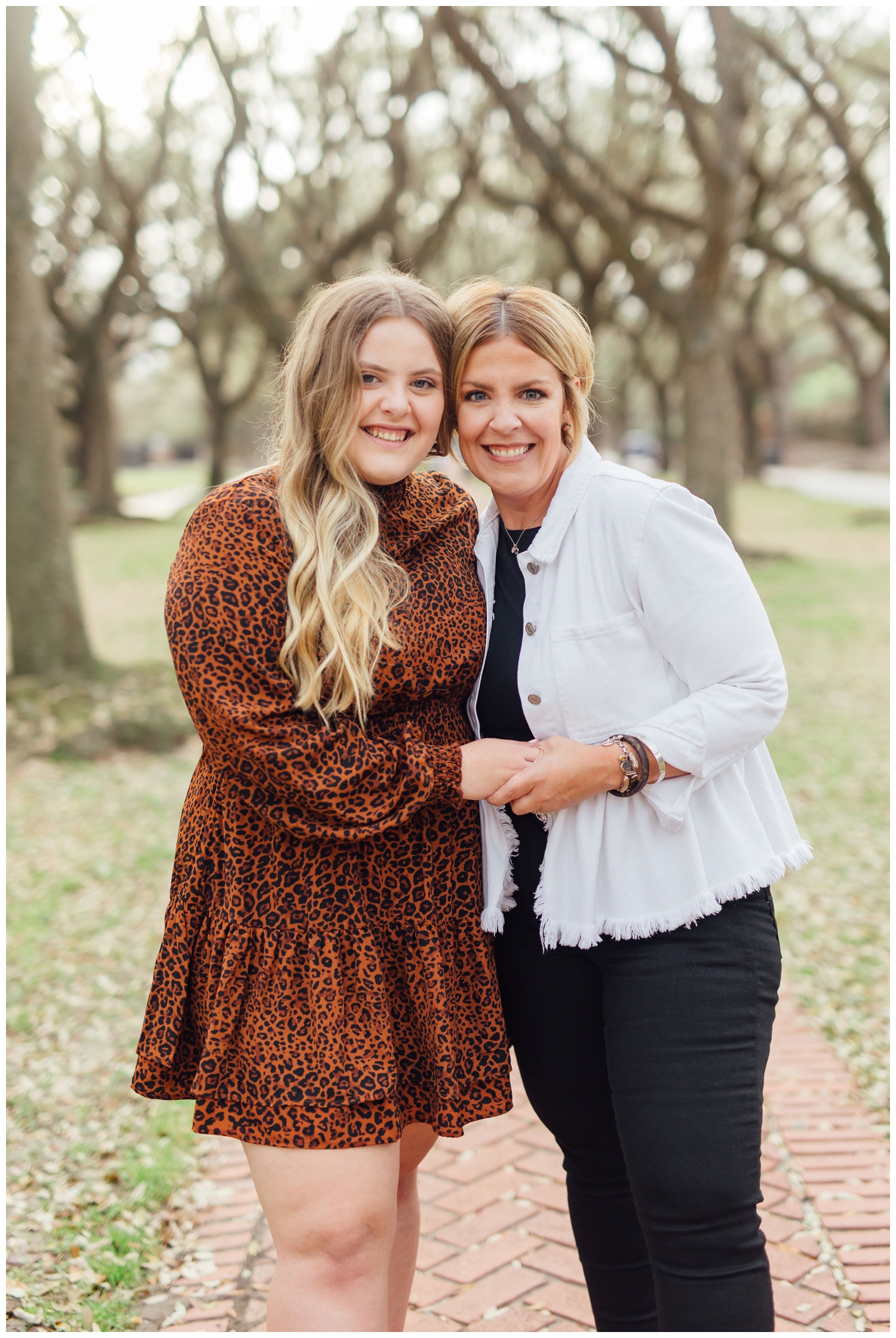 mom and daughter hugging on a sidewalk for senior photos downtown Houston