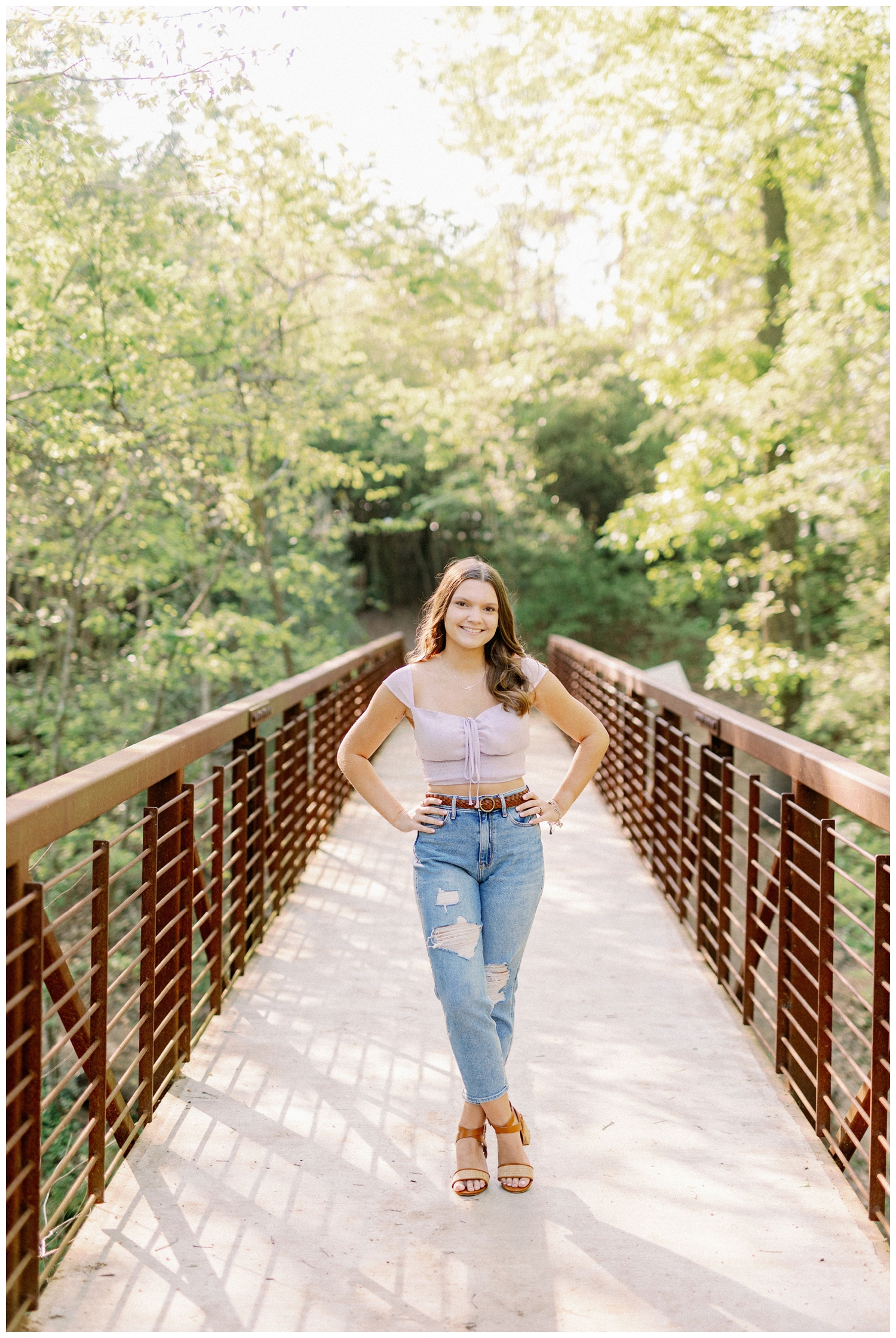 girl standing on bridge with hands on hips for senior photos Houston Arboretum