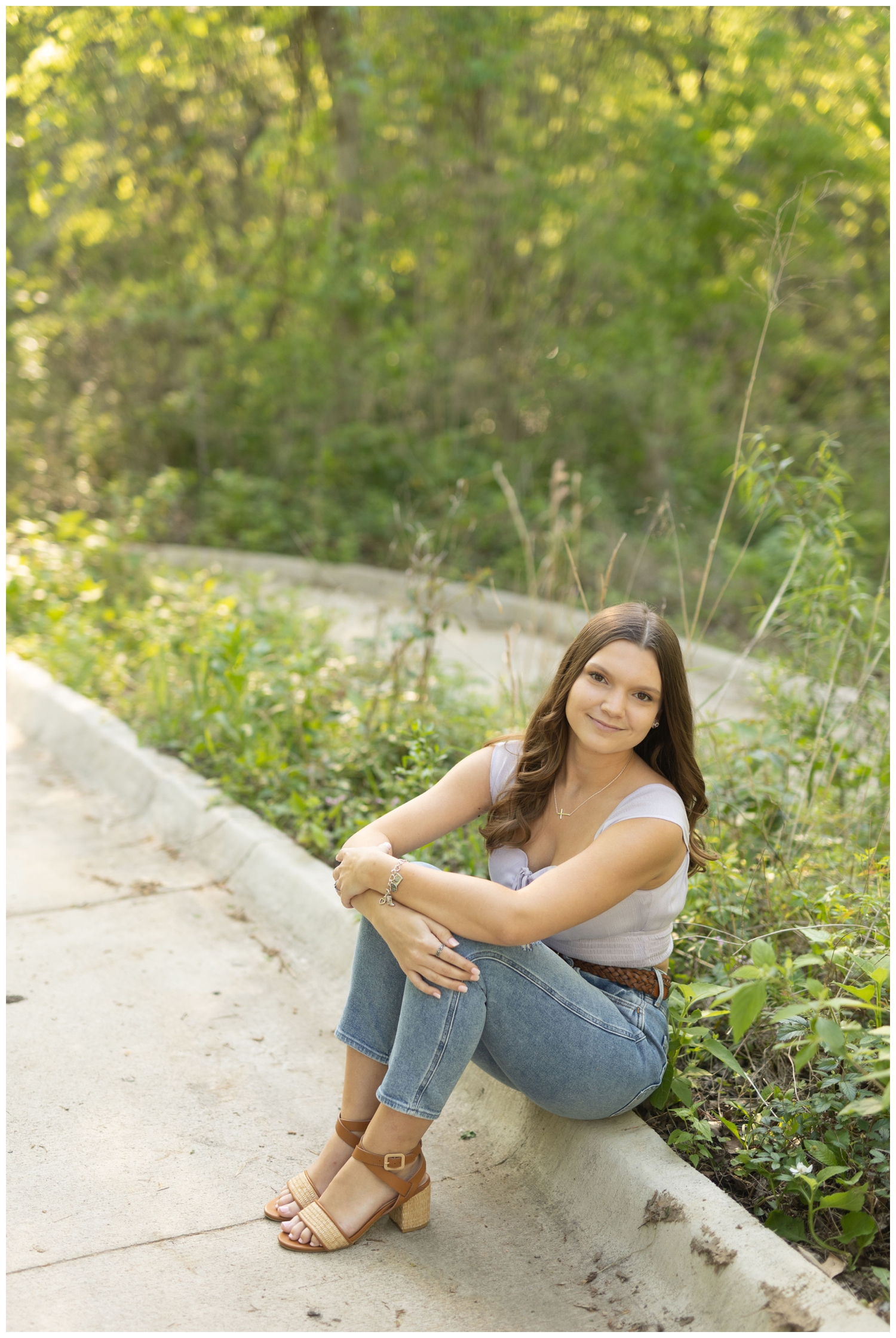 girl sitting on curb in a field