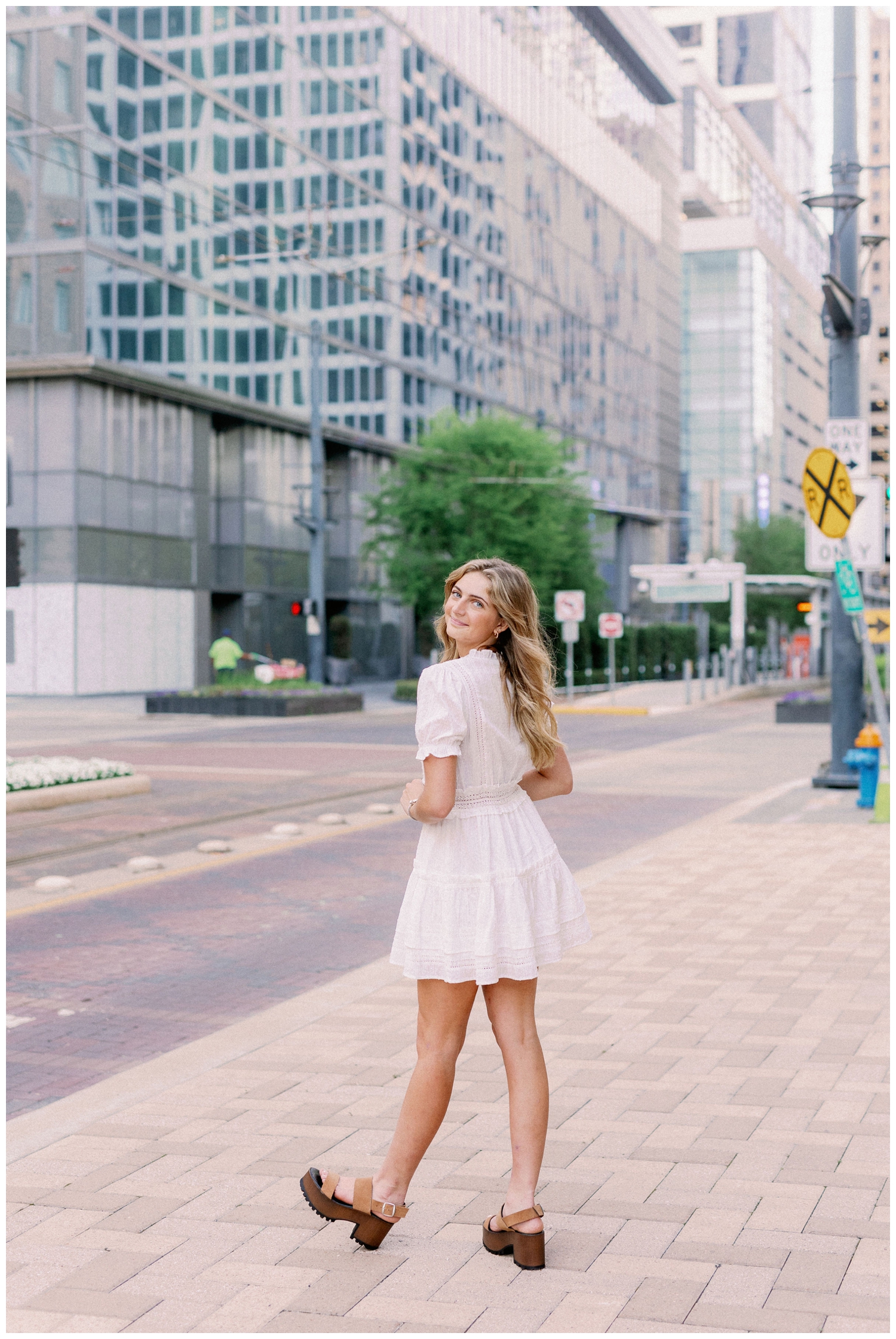 girl walking in front of city buildings downtown Houston