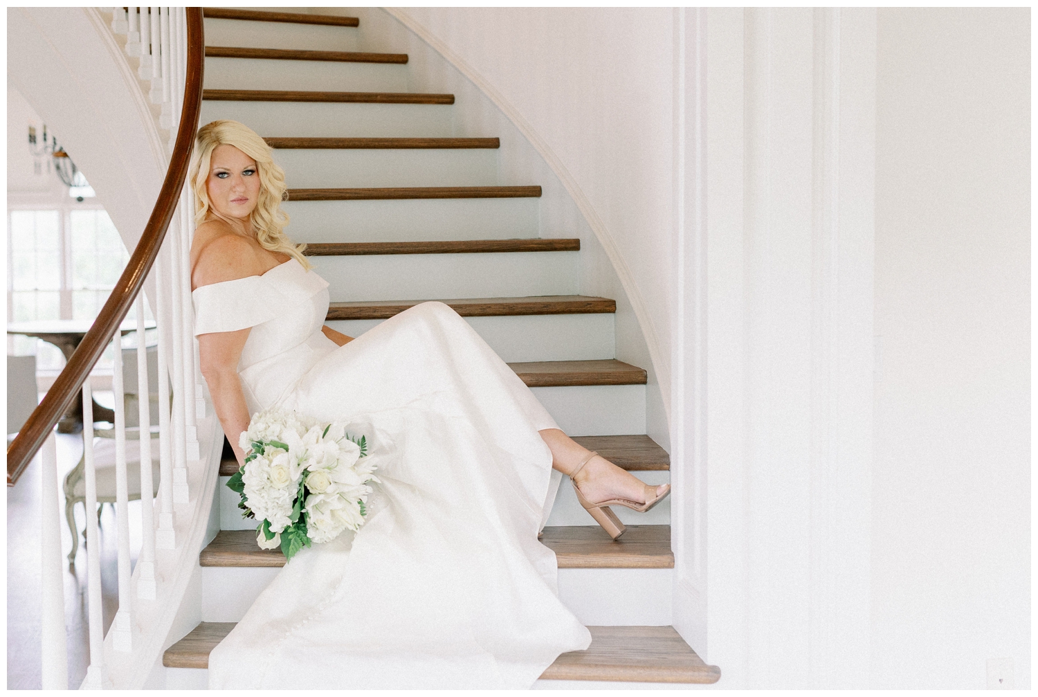 bride sitting on staircase in wedding gown inside The Creative Chateau