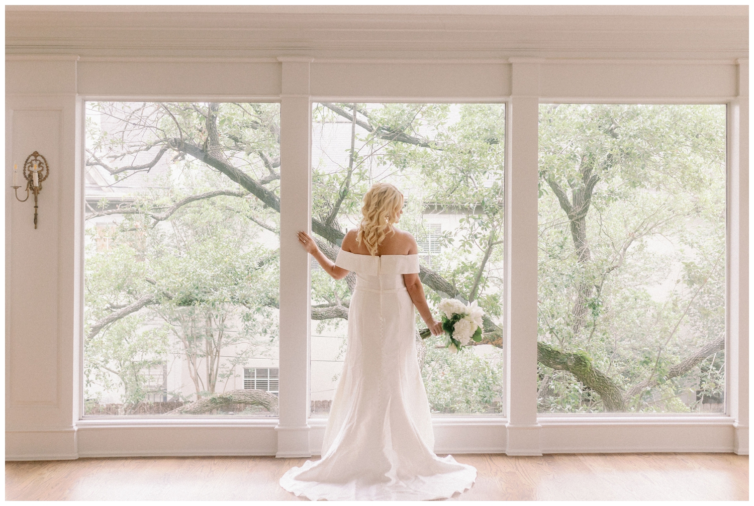 bridal portraits of bride looking out floor to ceiling windows