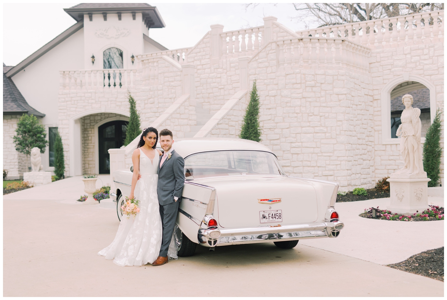 bride and groom standing by classic car in front of Brighton Abbey wedding venue