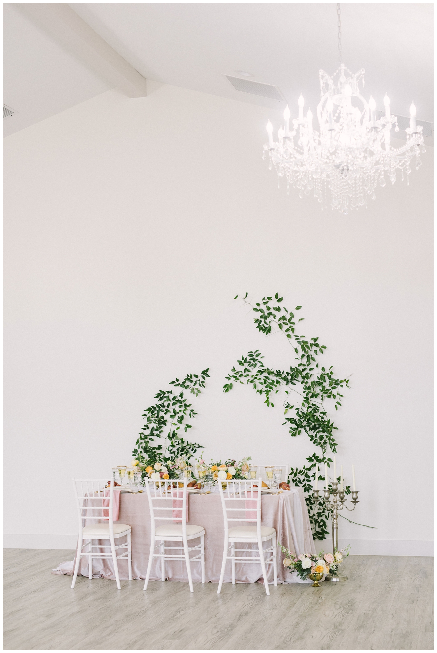 European inspired pink reception table with greenery on the wall inside Brighton Abbey wedding venue in Aubrey, Texas